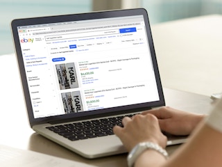 person on laptop looking at karl lagerfeld barbies sold on ebay