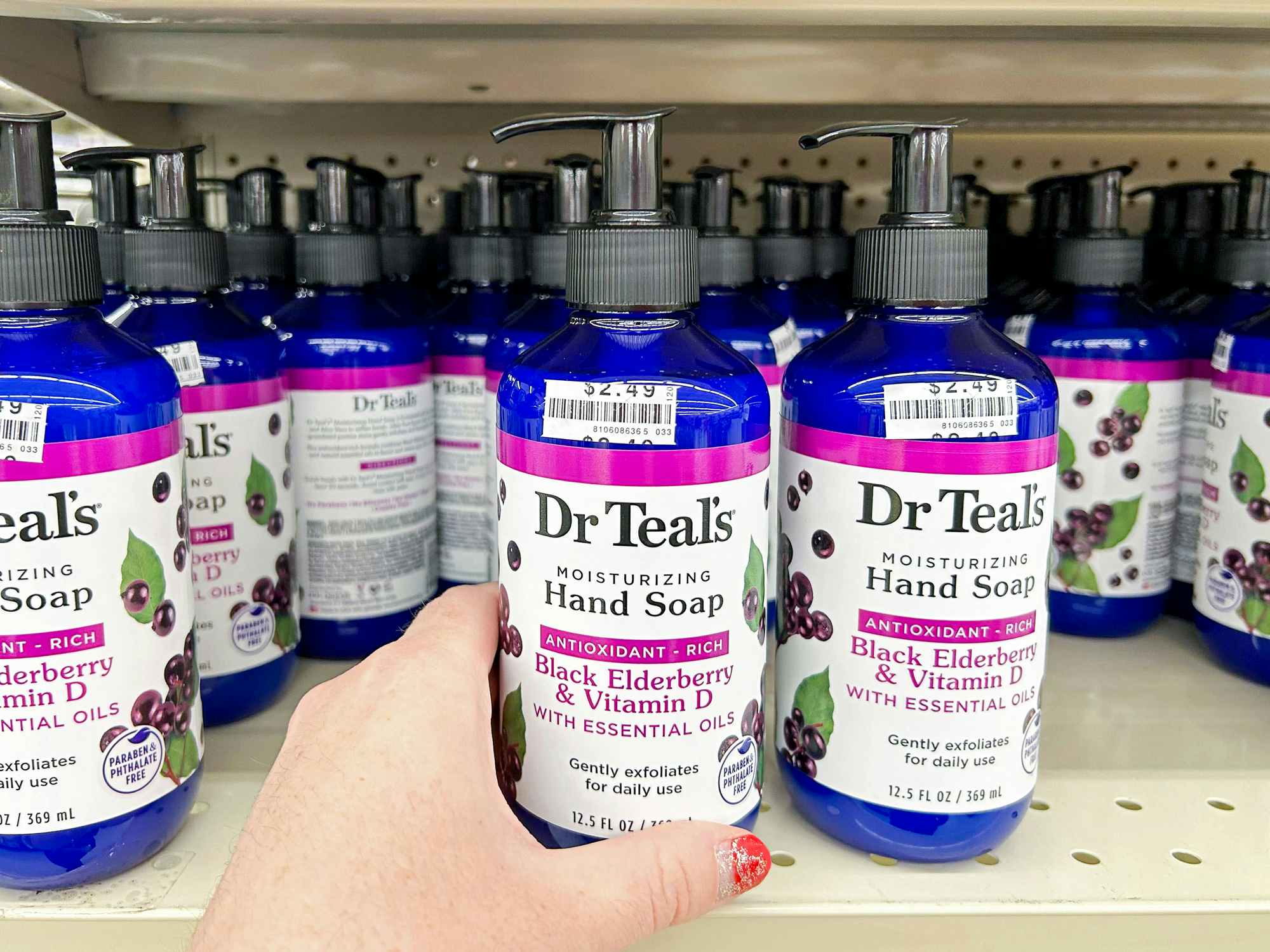 person grabbing dr teals hand soap off shelf in big lots