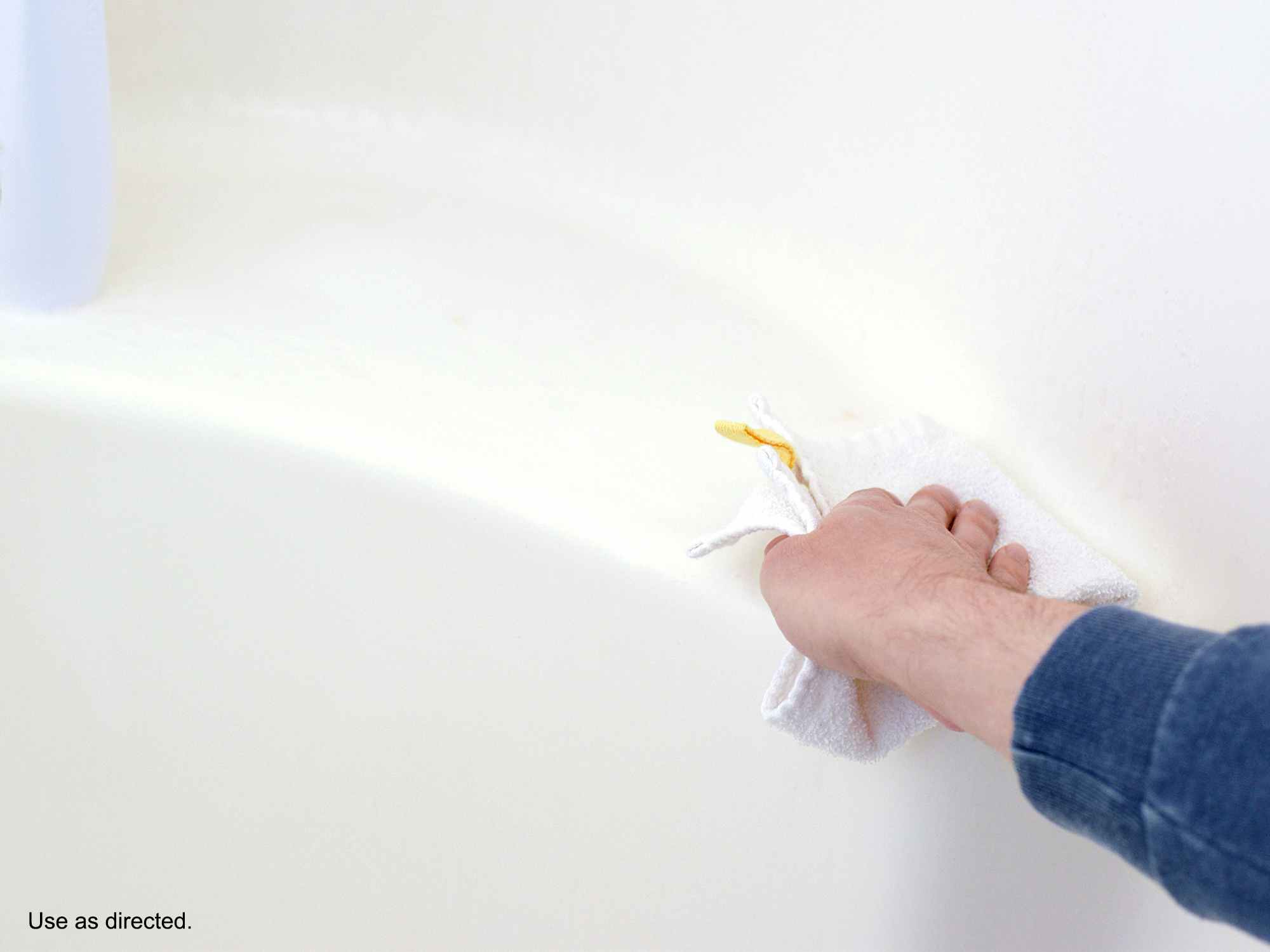 person wiping bathtub ledge after spraying clorox bathroom ultra foamer spray