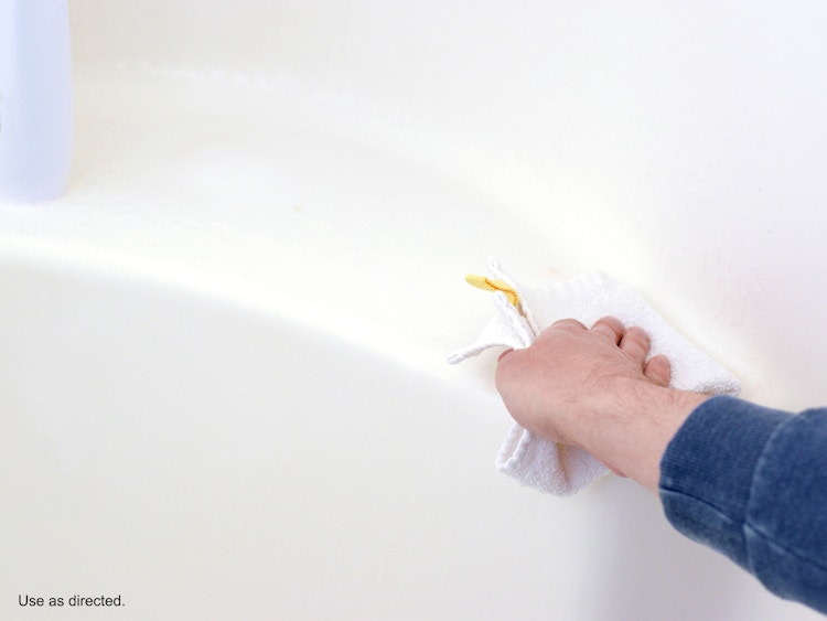 person wiping bathtub ledge after spraying clorox bathroom ultra foamer spray