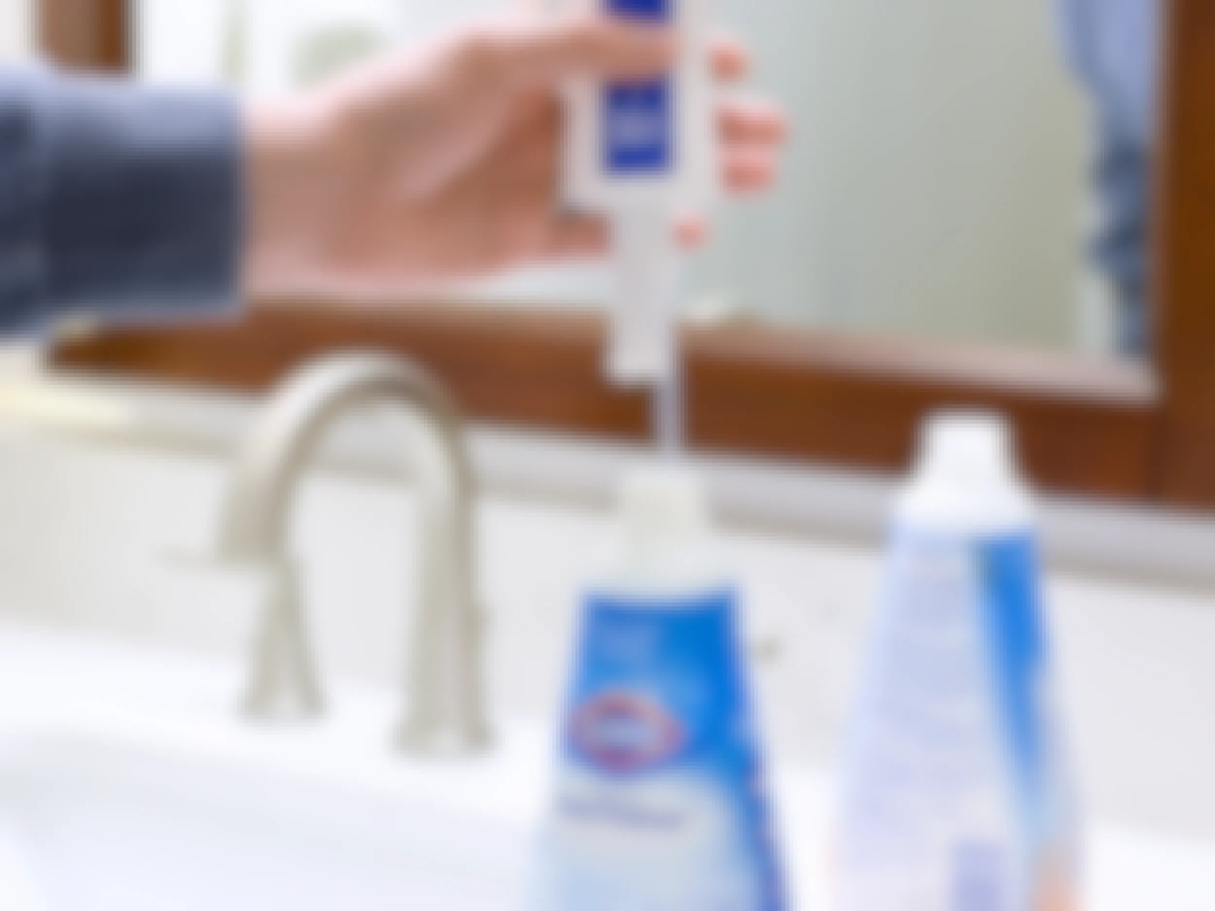 person lifting sprayer nozzle from clorox ultra foamer bathroom cleaner