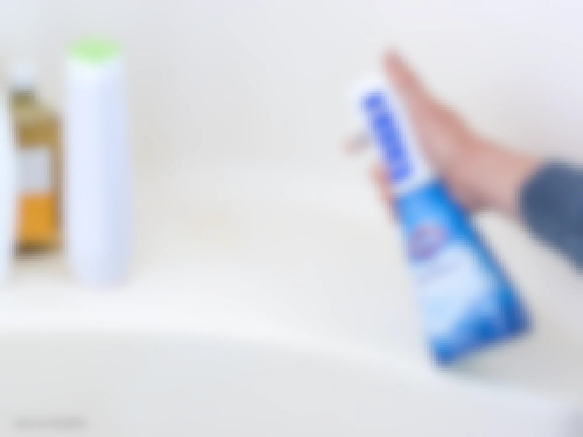 person spraying mildew in bathtub with clorox bathroom ultra foamer cleaner