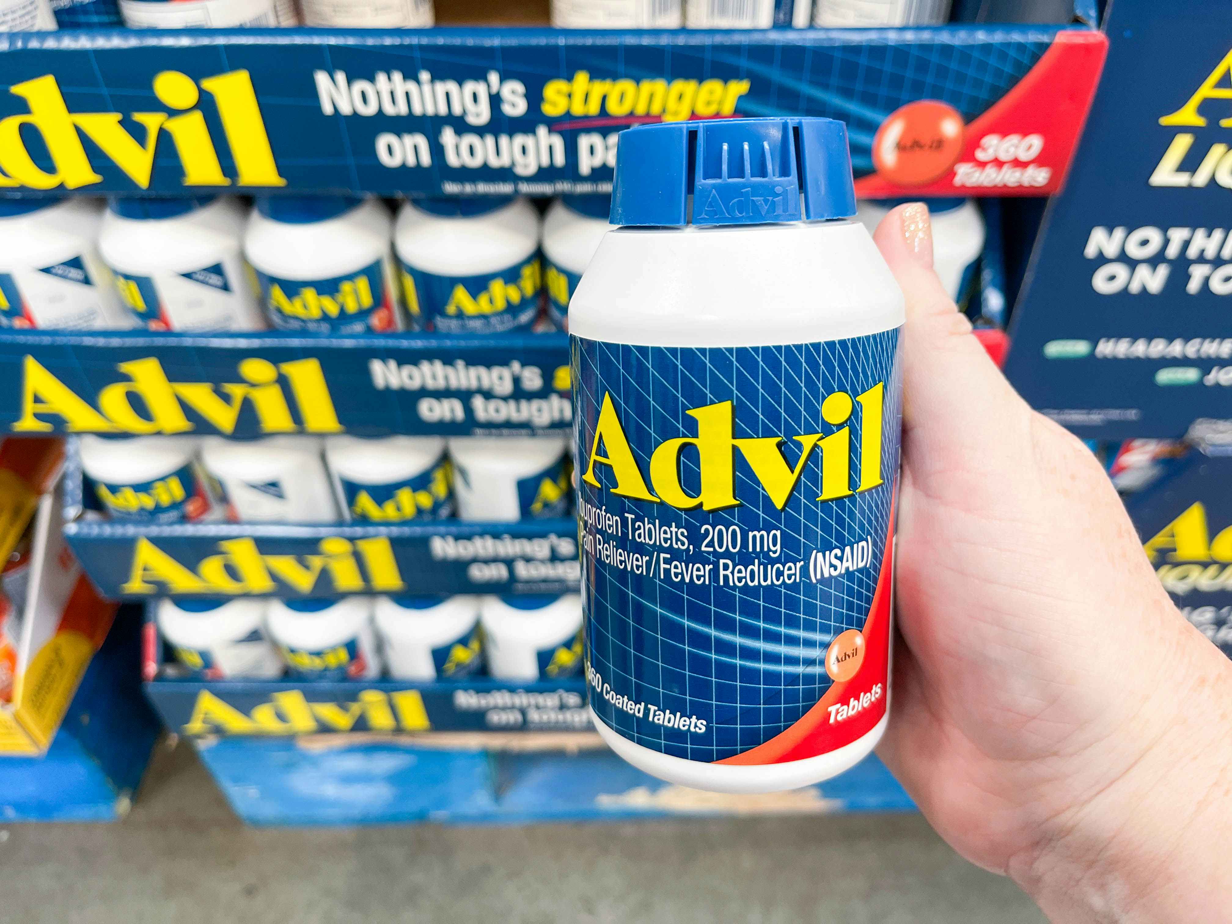 a bottle of advil being held in store