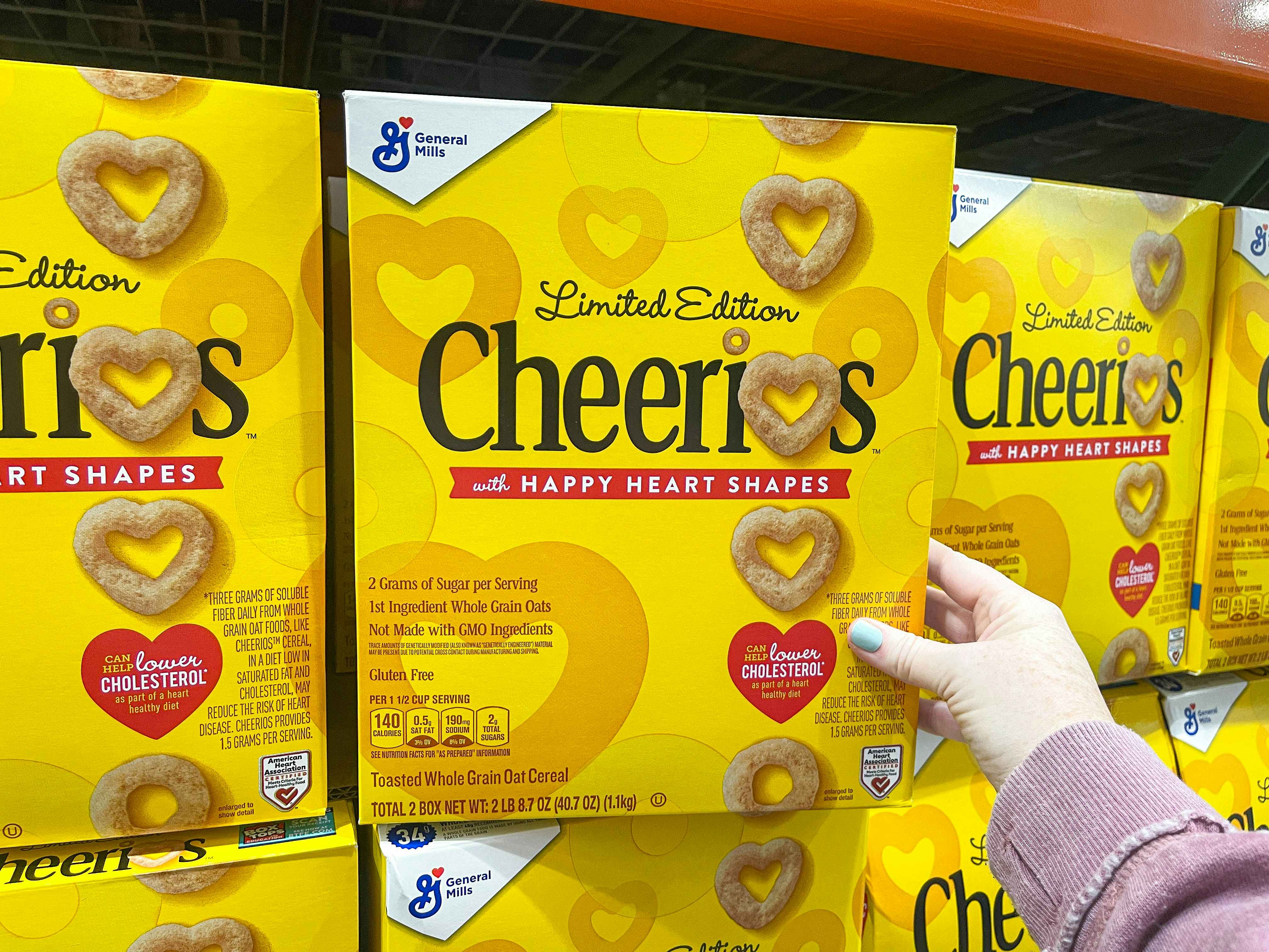 a box of cherrios being held in store 