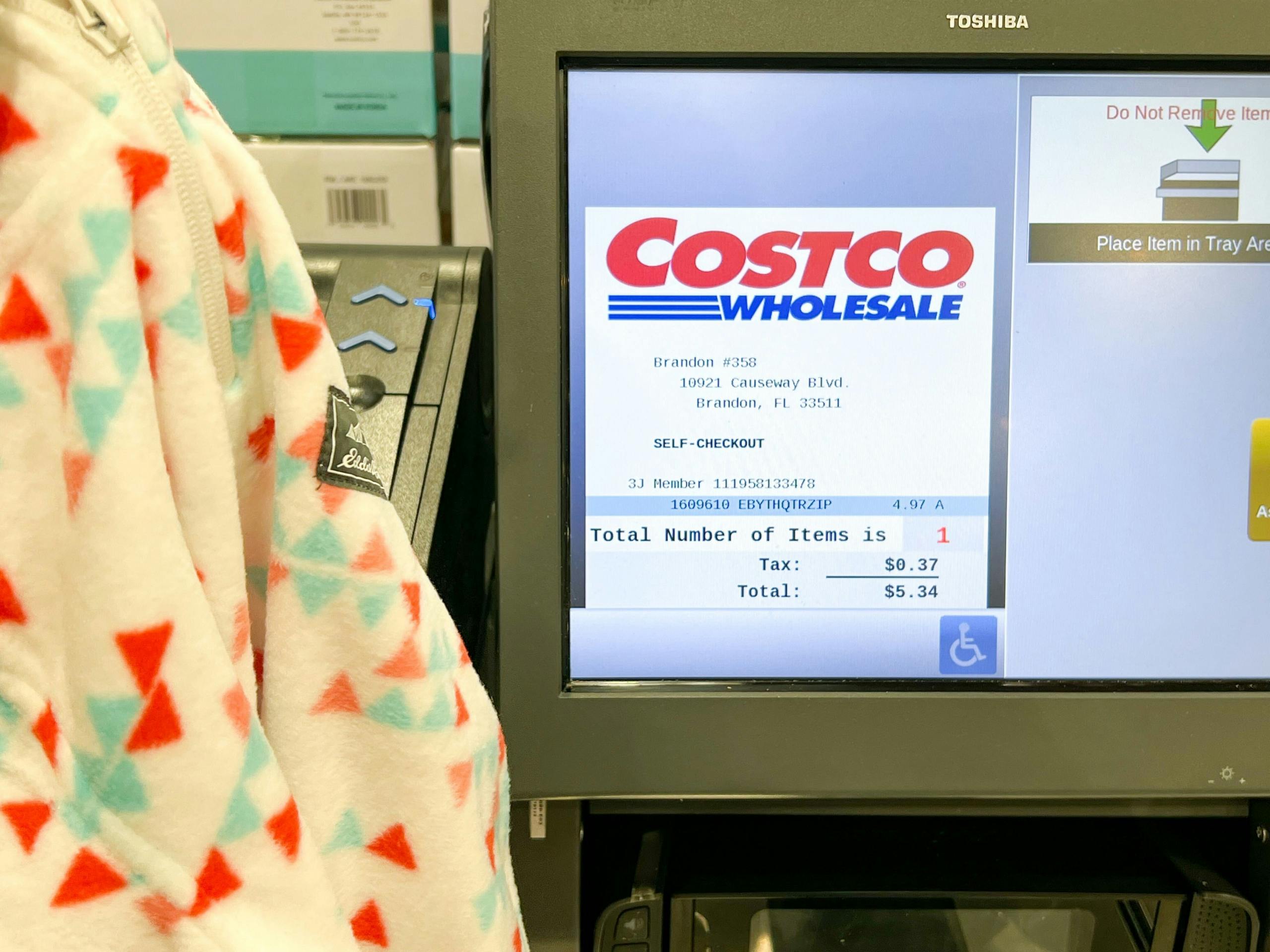 holding a kids eddie bauer fleece by the costco register showing 4.97 price