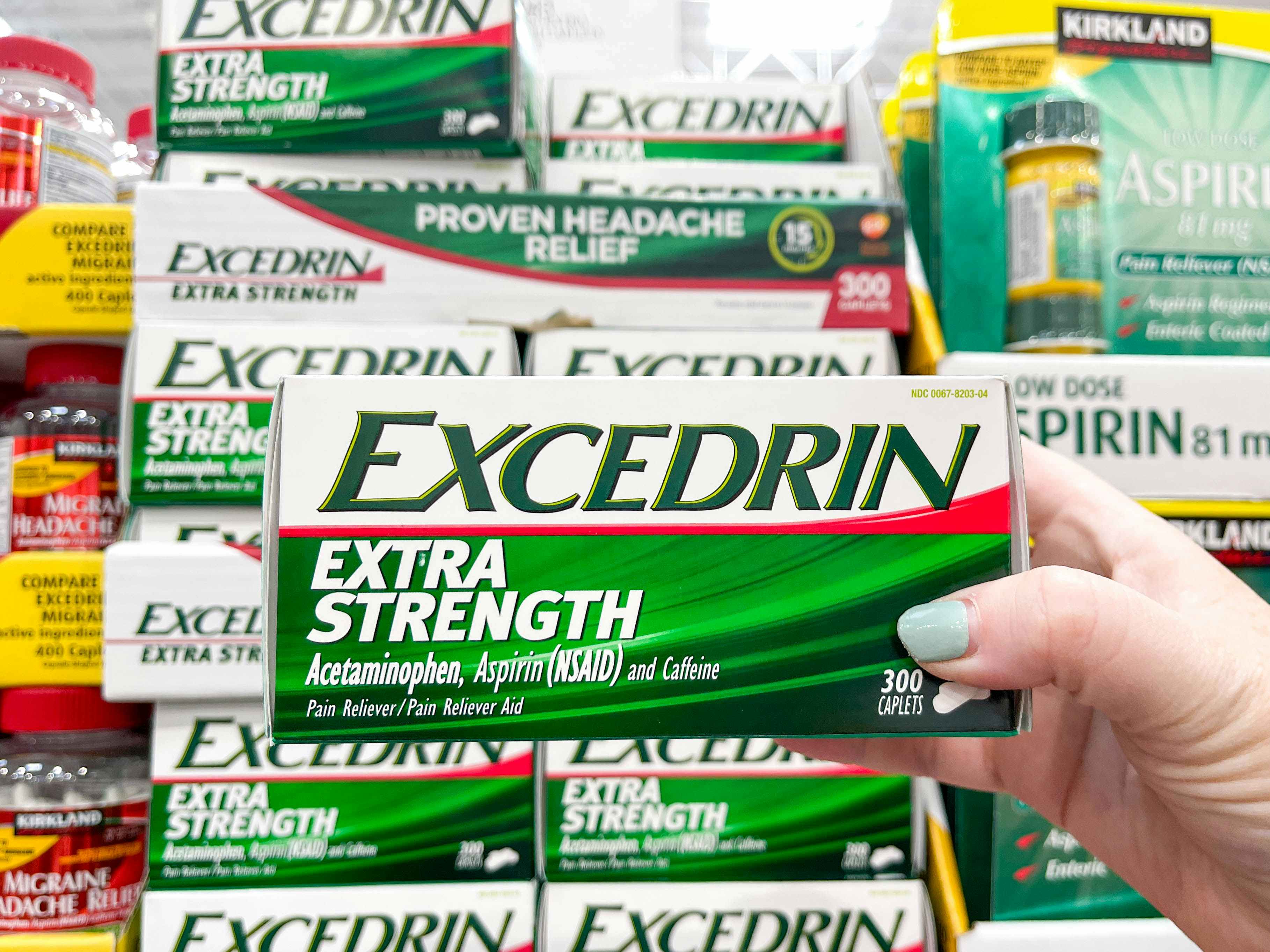 a person holding up excedrin box
