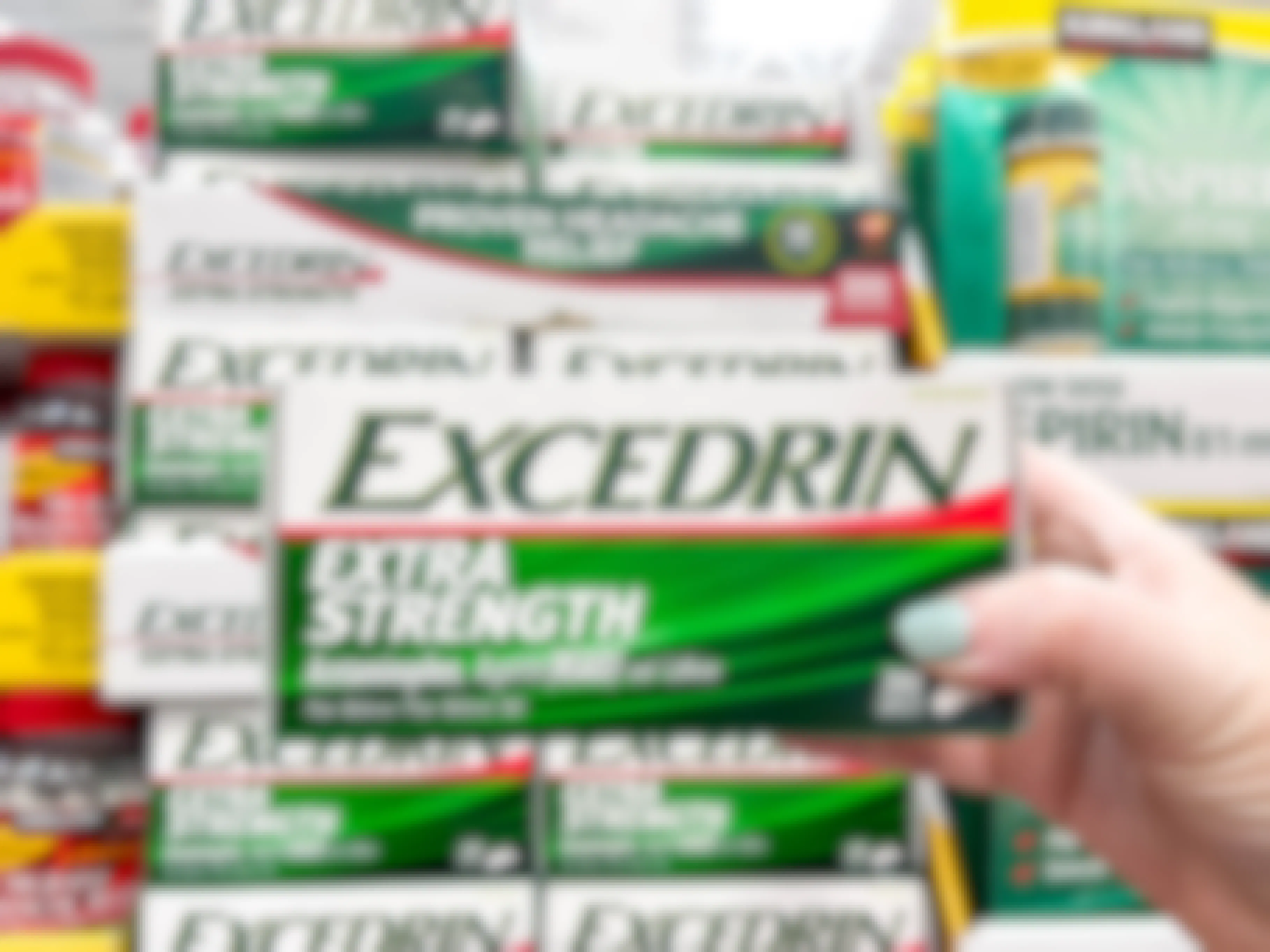 a person holding up excedrin box 