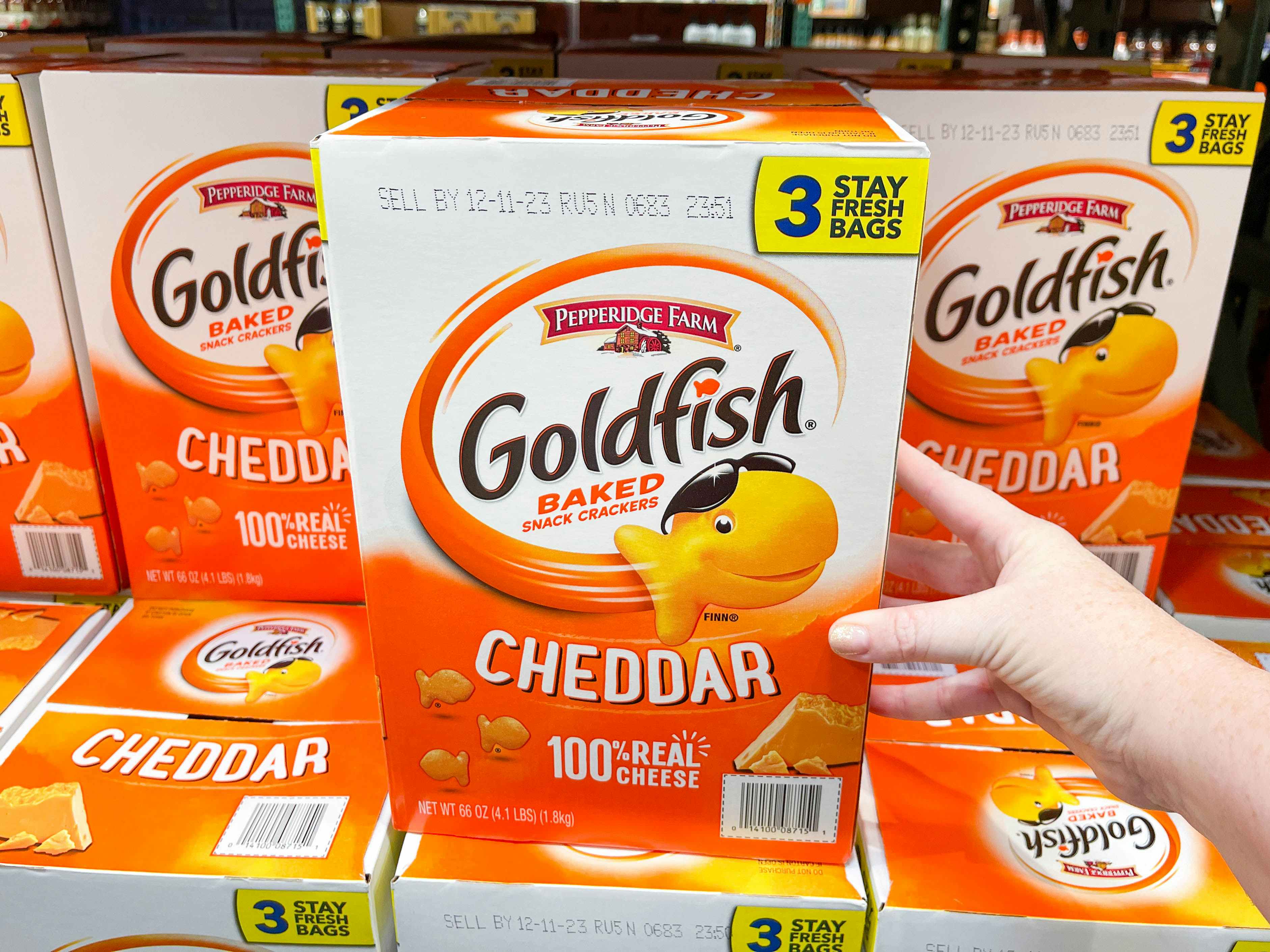 a large box of goldfish crackers being grabbed in store
