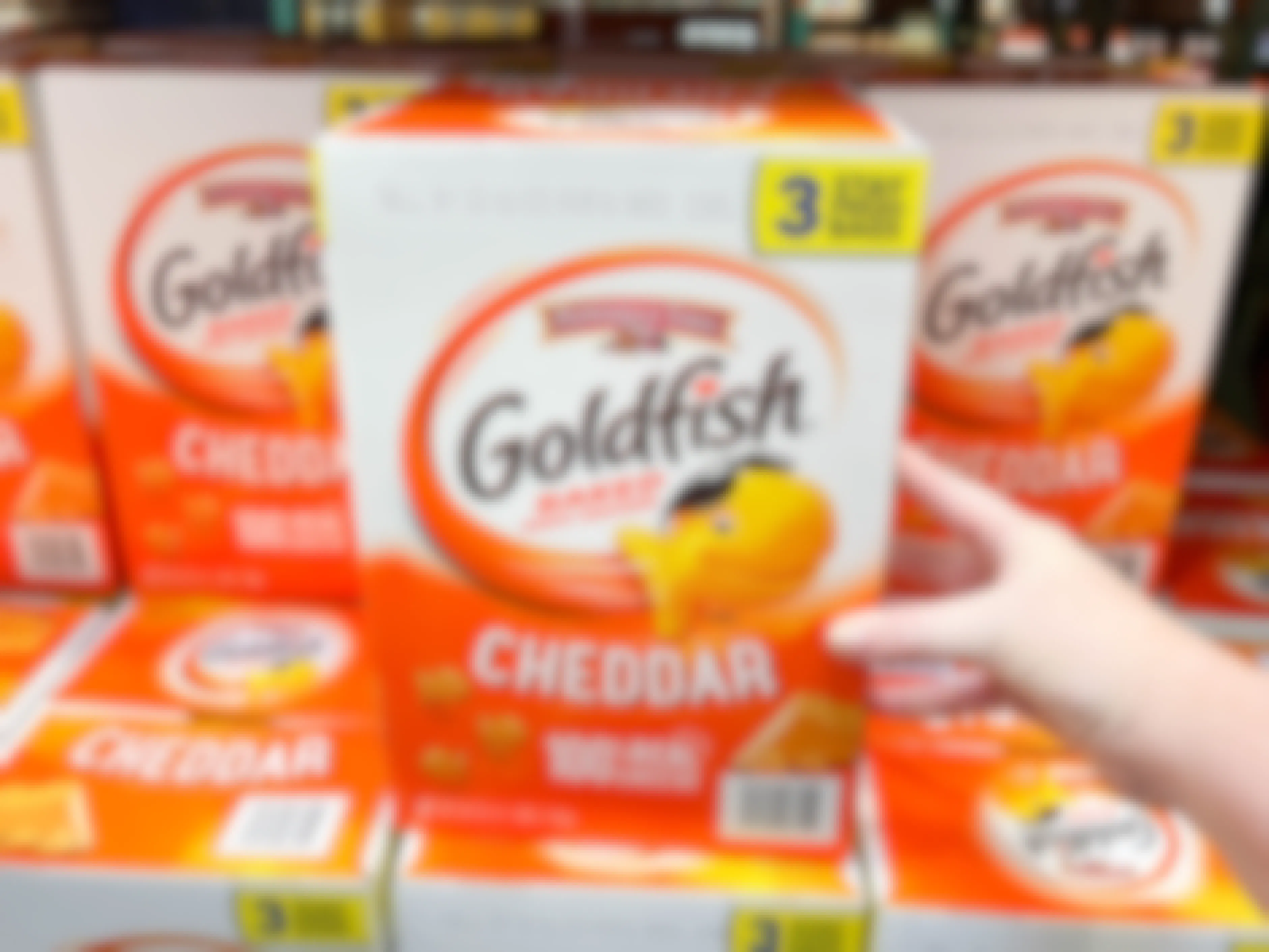a large box of goldfish crackers being grabbed in store