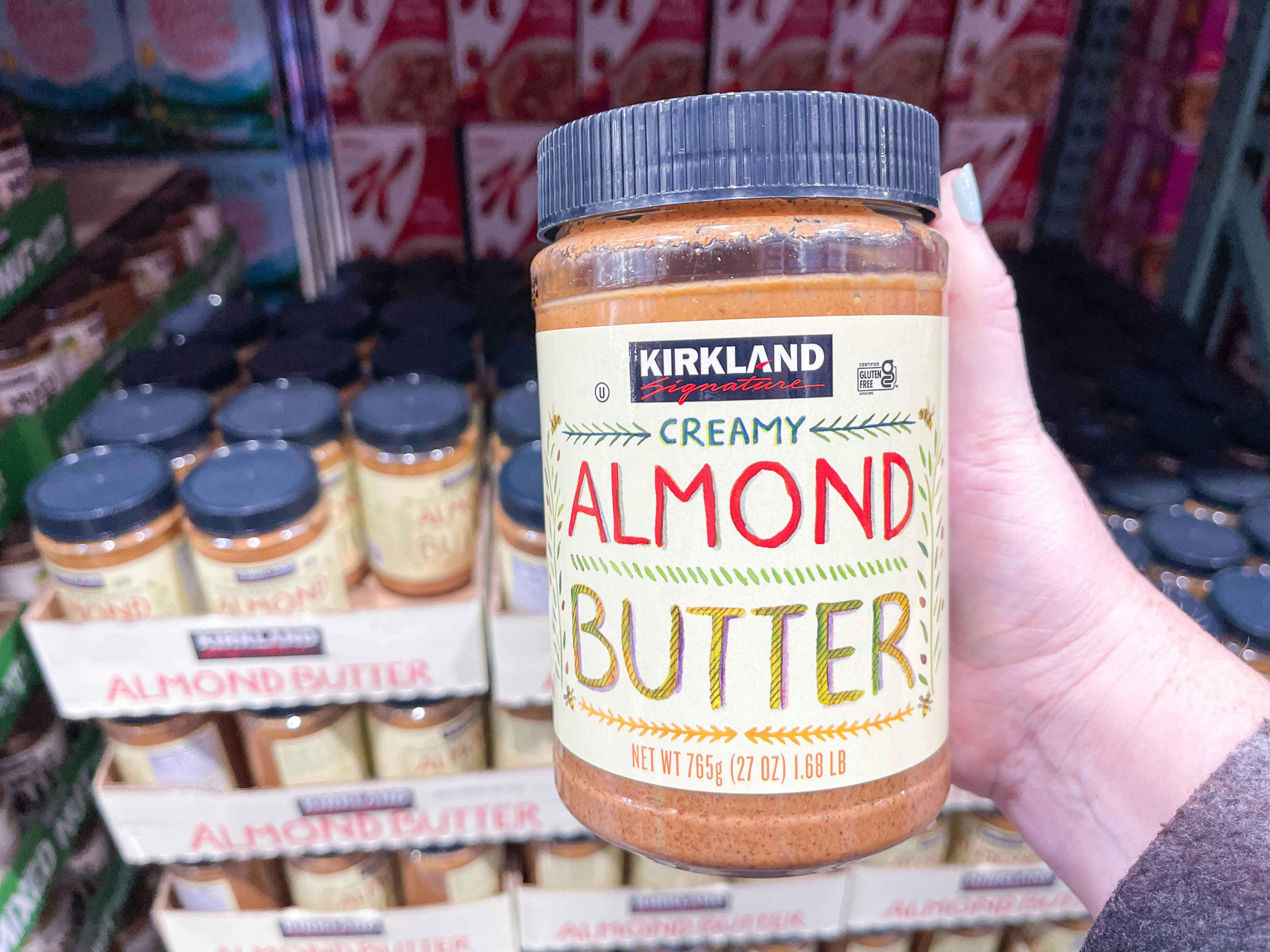 a person holding up almond butter