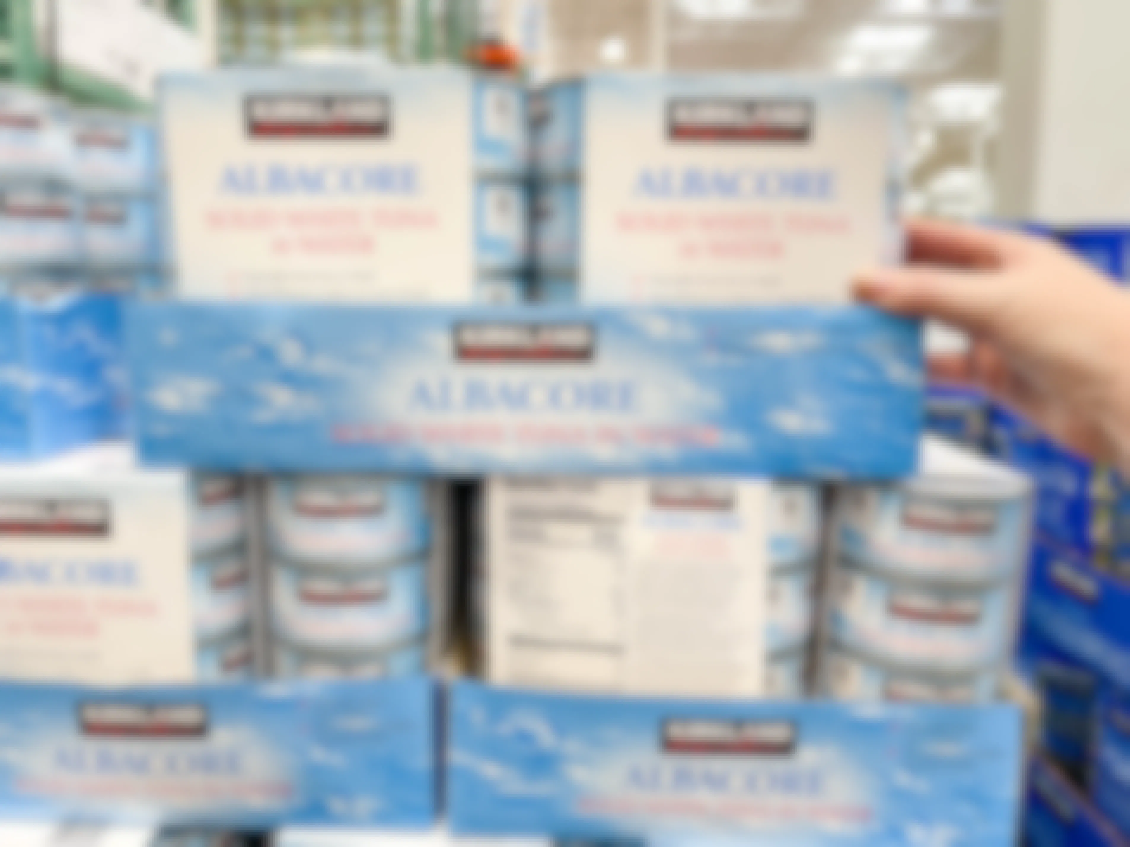 a package of tuna fish containers being grabbed in store