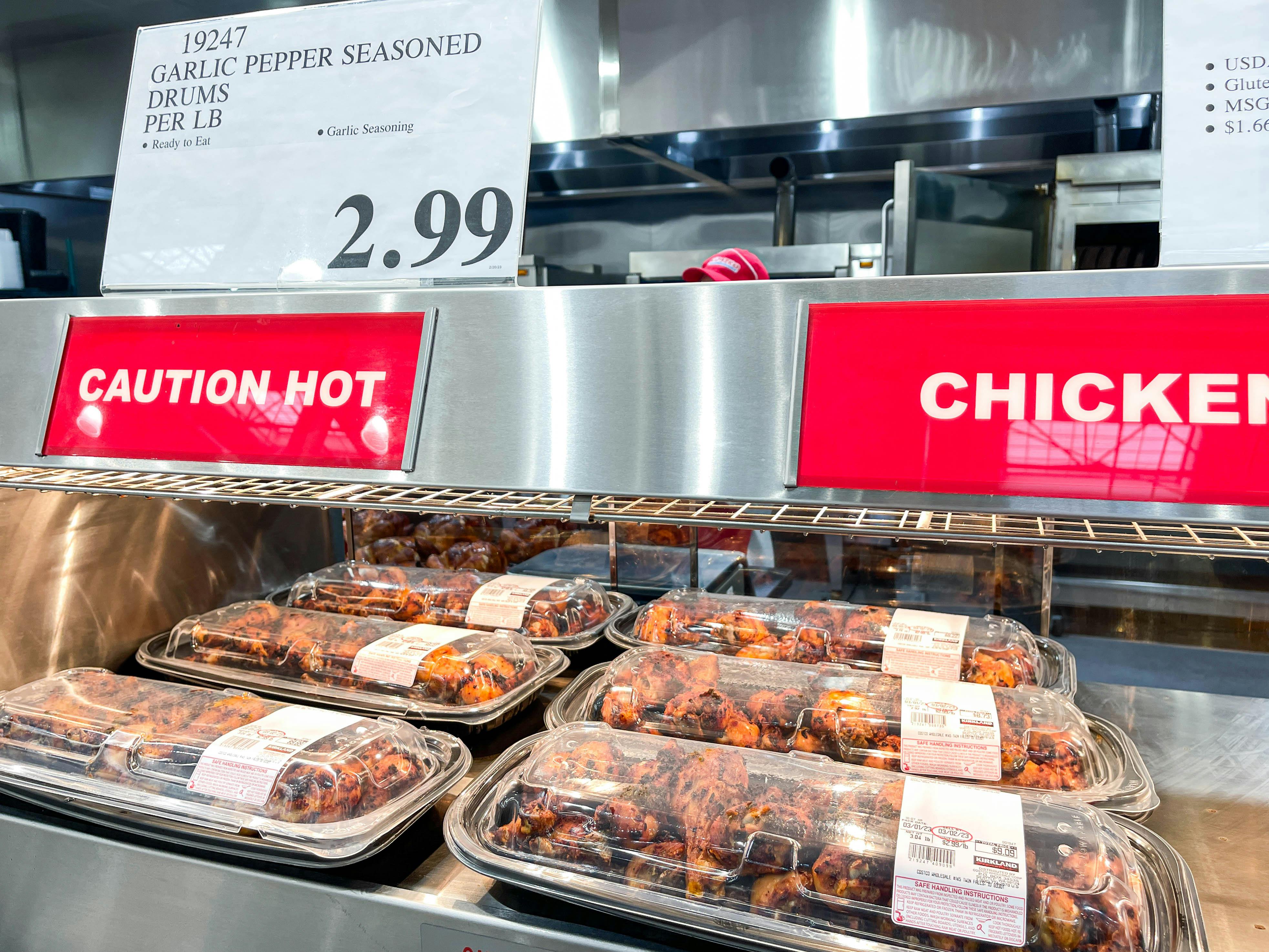 a display of packaged chicken drumsticks in costco hot case 