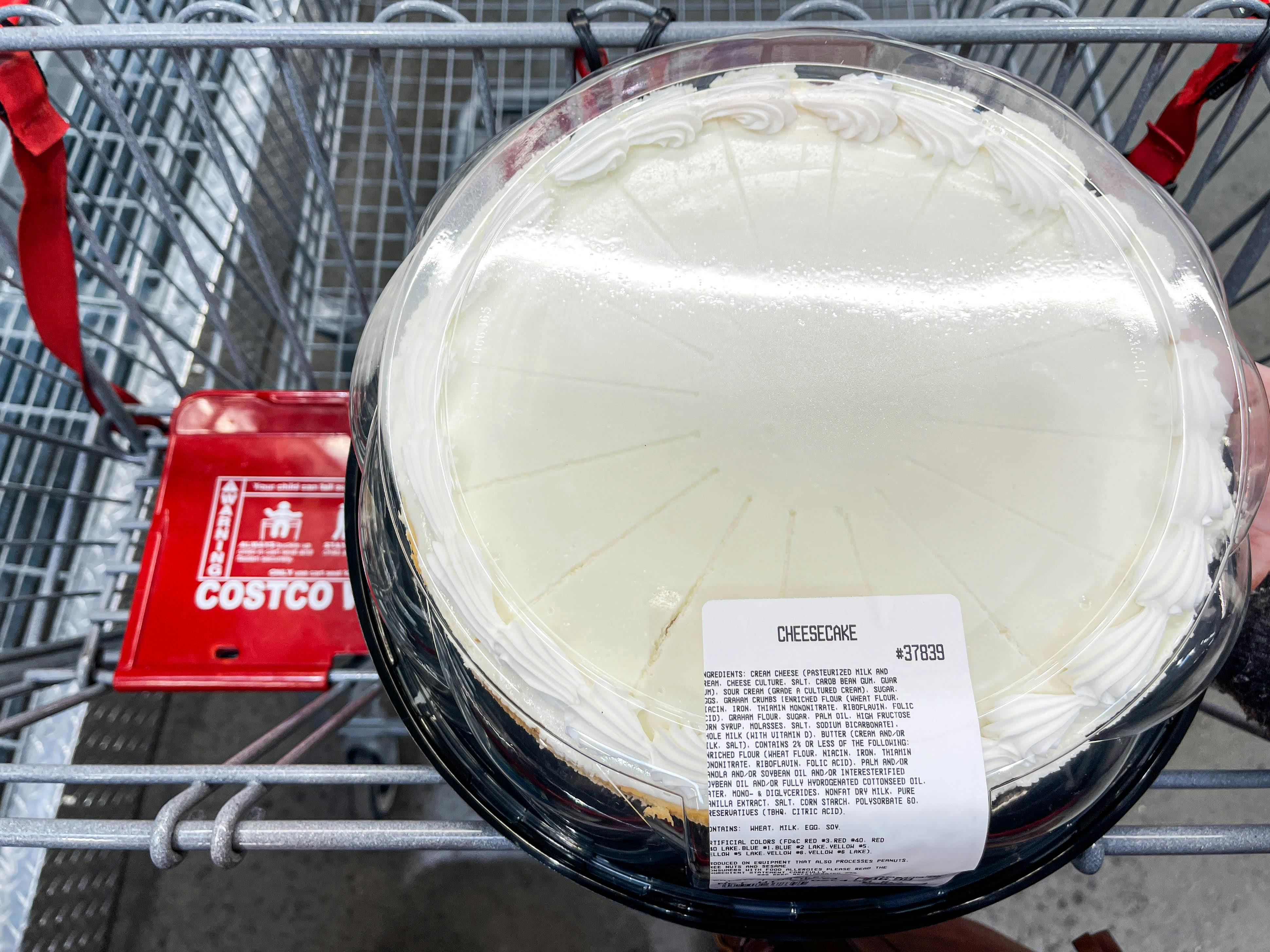 a person putting a large cheesecake in cart 