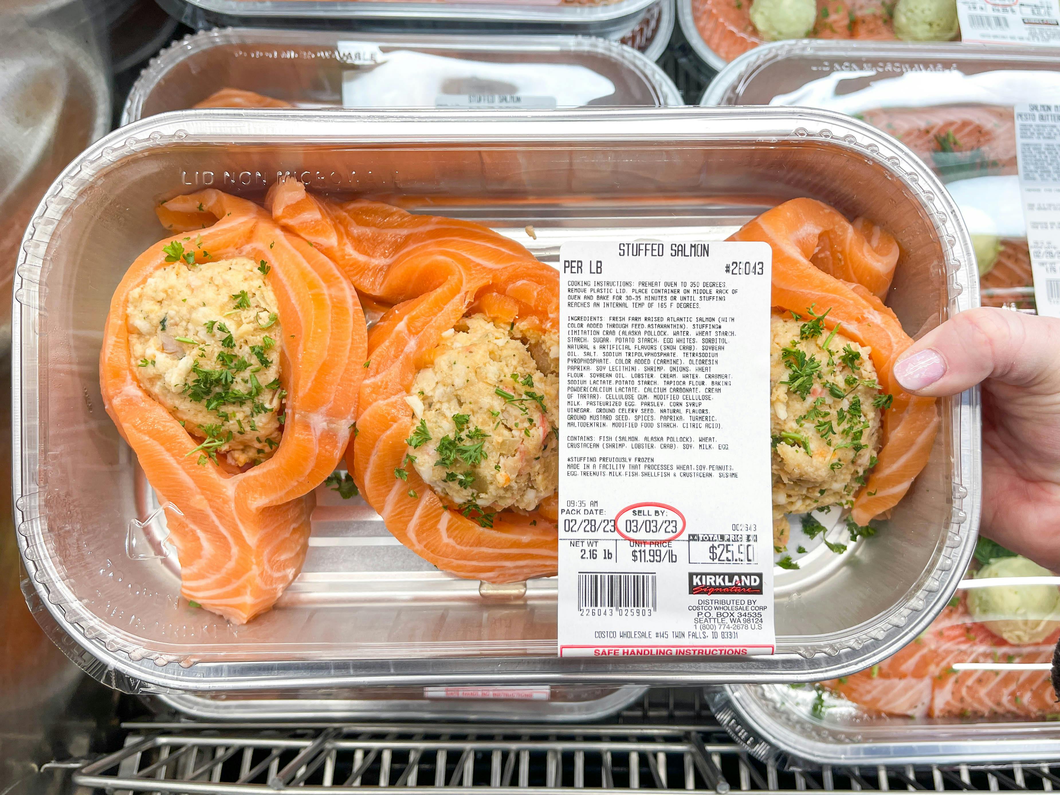 a person holding up a costco stuffed salmon meal in store