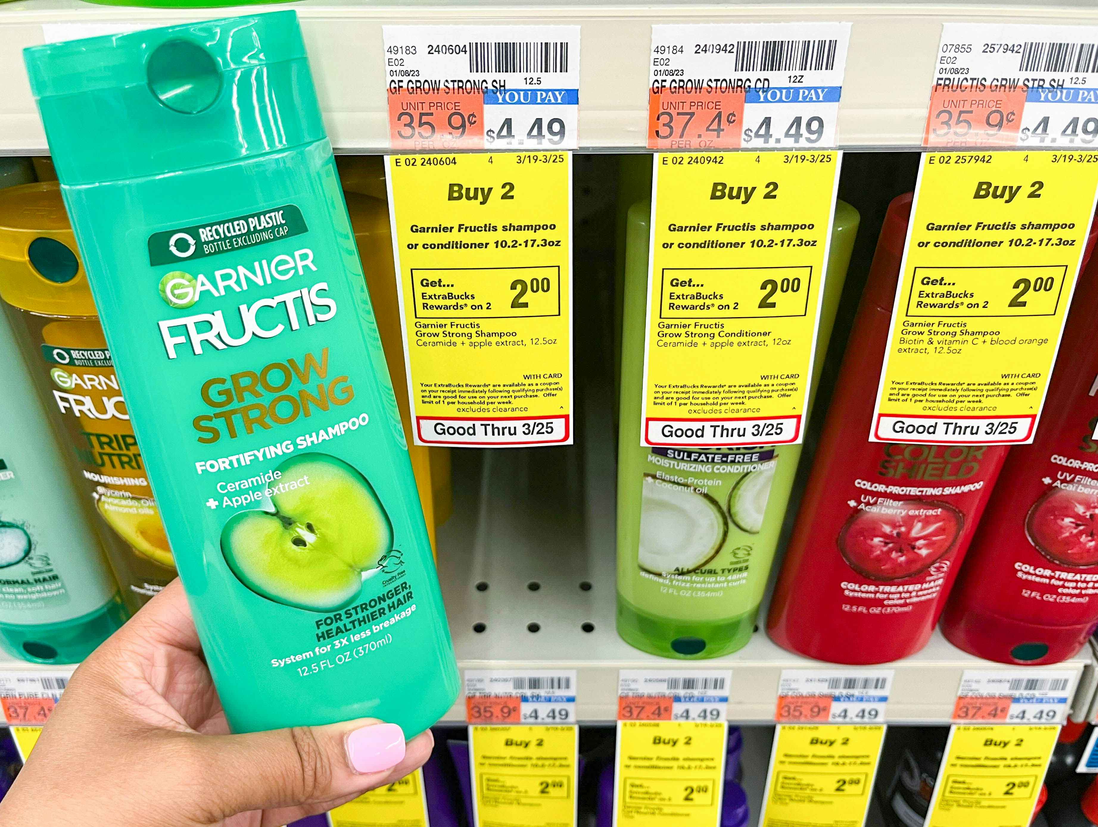 hand holding bottle of Garnier Fructis shampoo next to sales tag