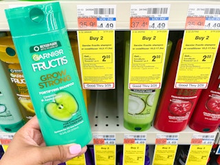 hand holding bottle of Garnier Fructis shampoo next to sales tag