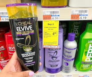 hand holding bottle of L'Oreal Paris Elvive shampoo next to sales tag