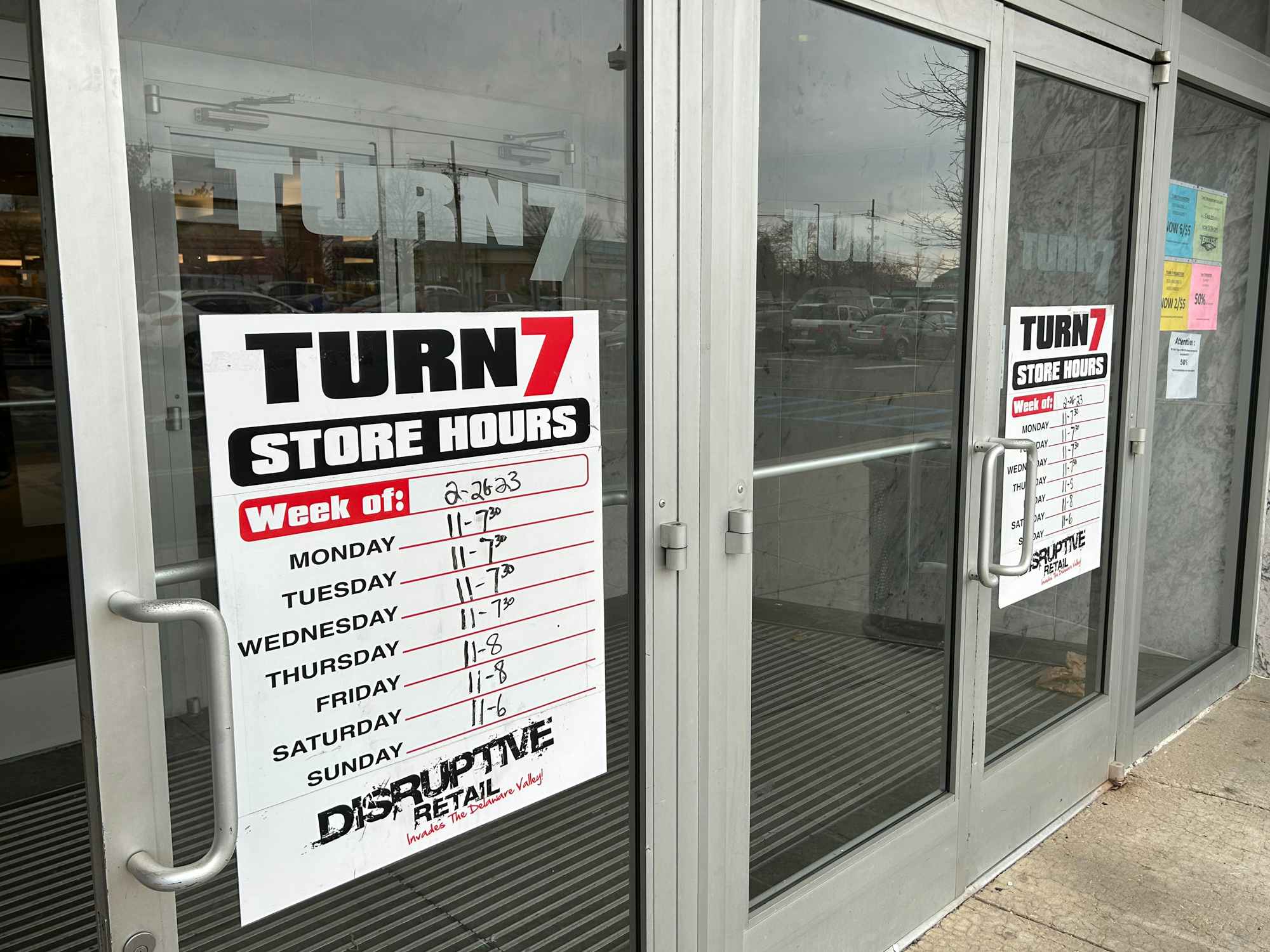 Turn7 store front entrance and hours sign posted on the window