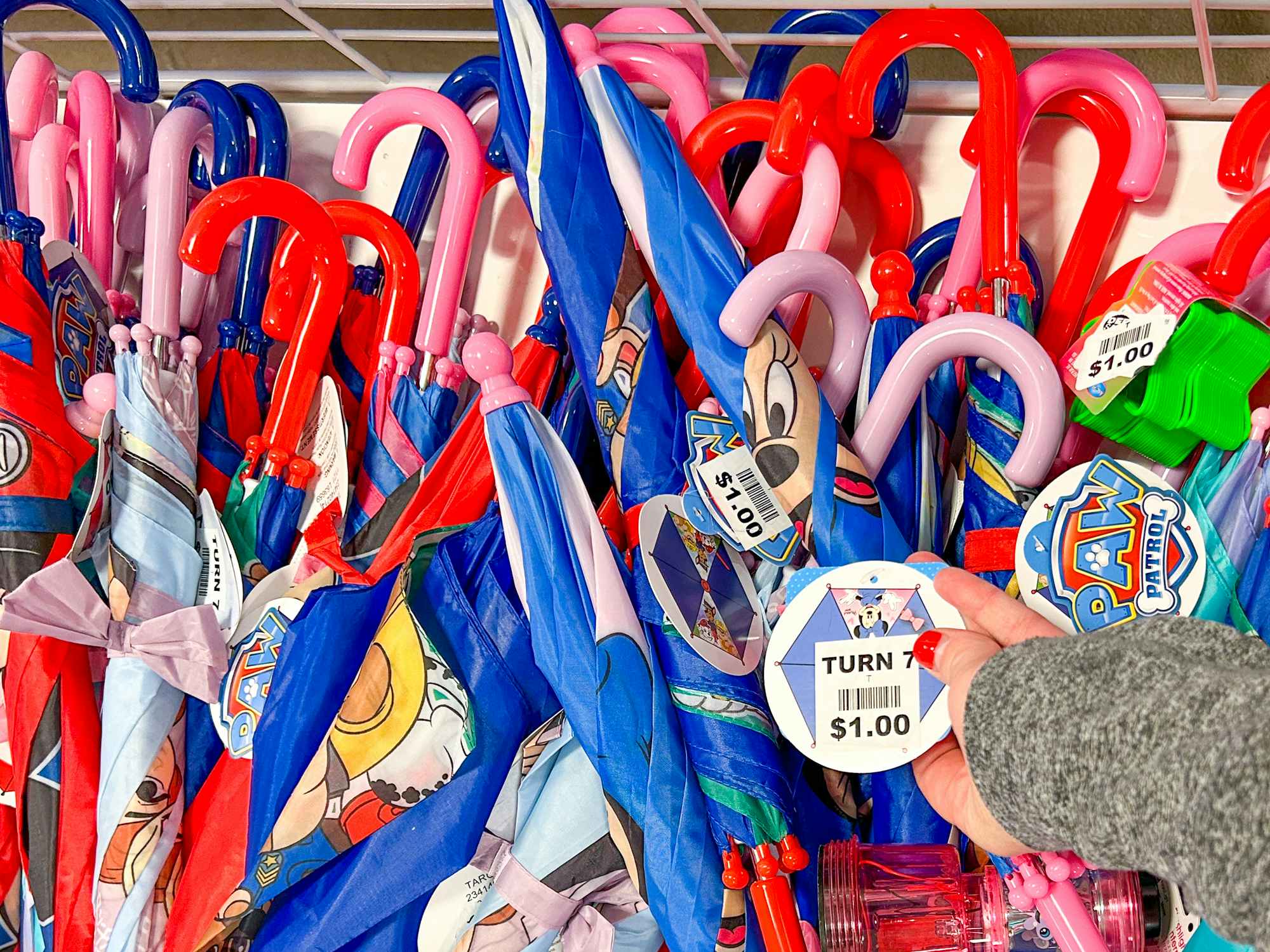 Umbrellas marked as $1 each in a bin at Turn7