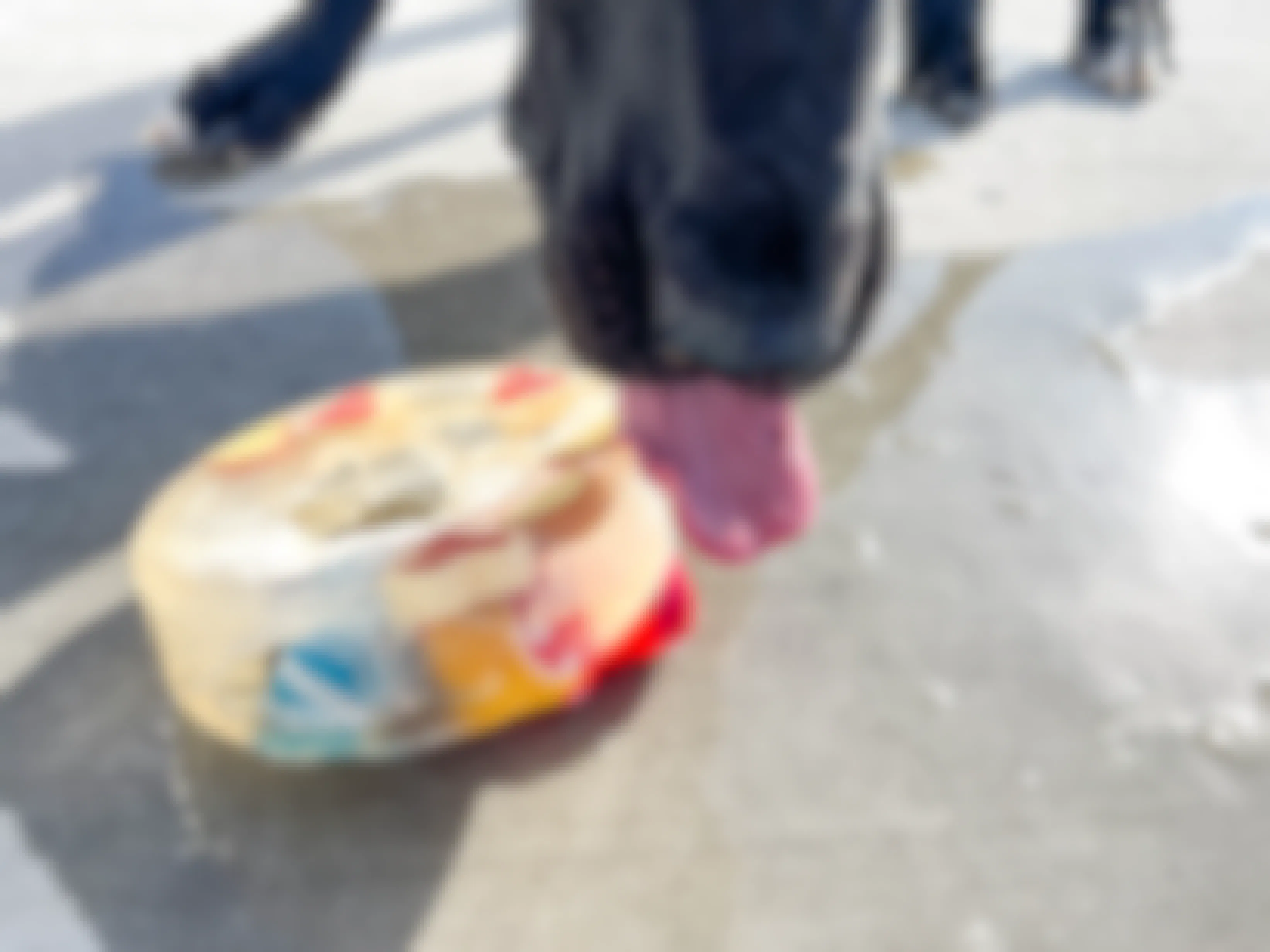 a dog licking a large frozen ice block with treats and toys inside 
