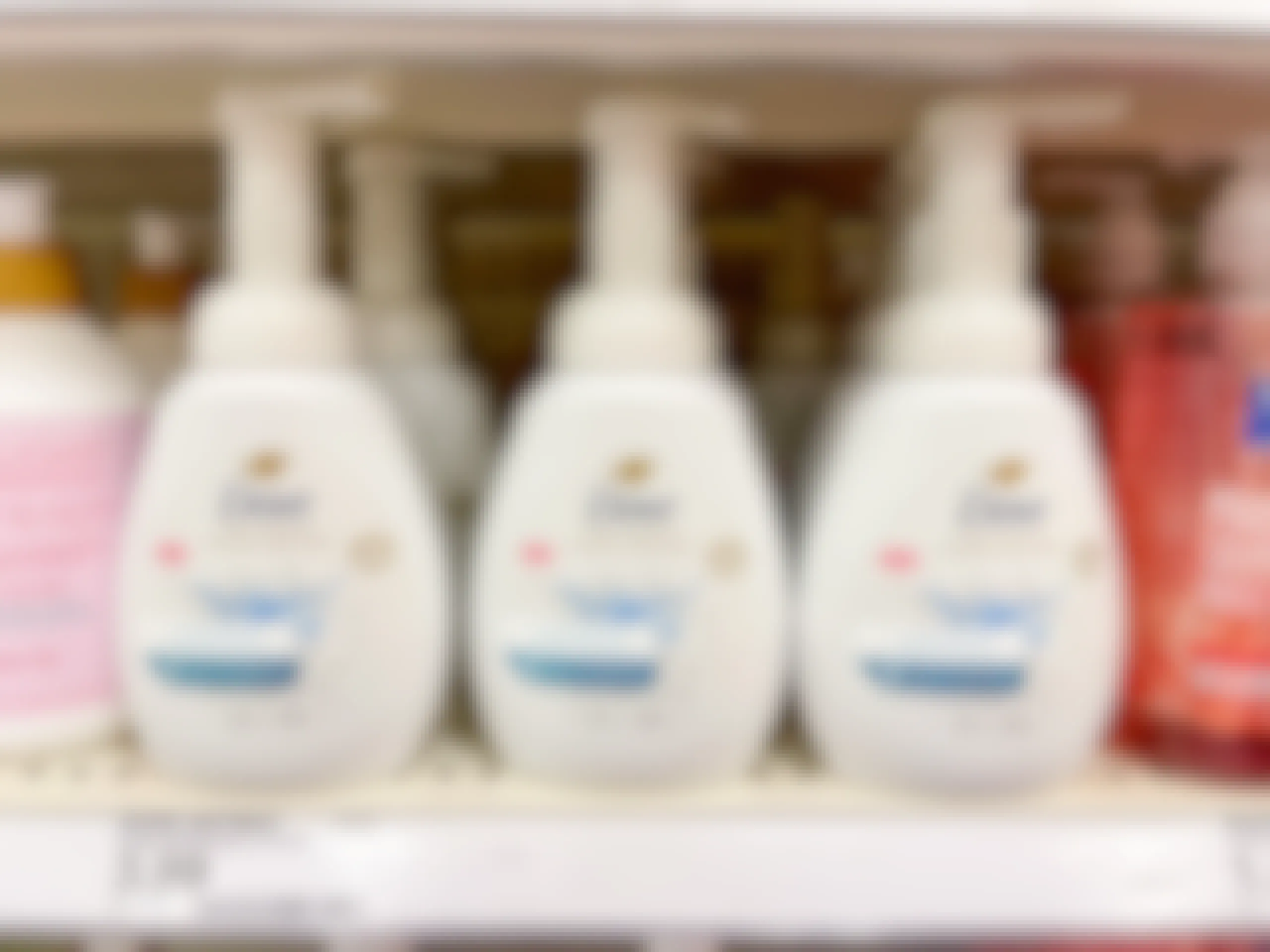 Several Dove hand soaps sitting on a store shelf.