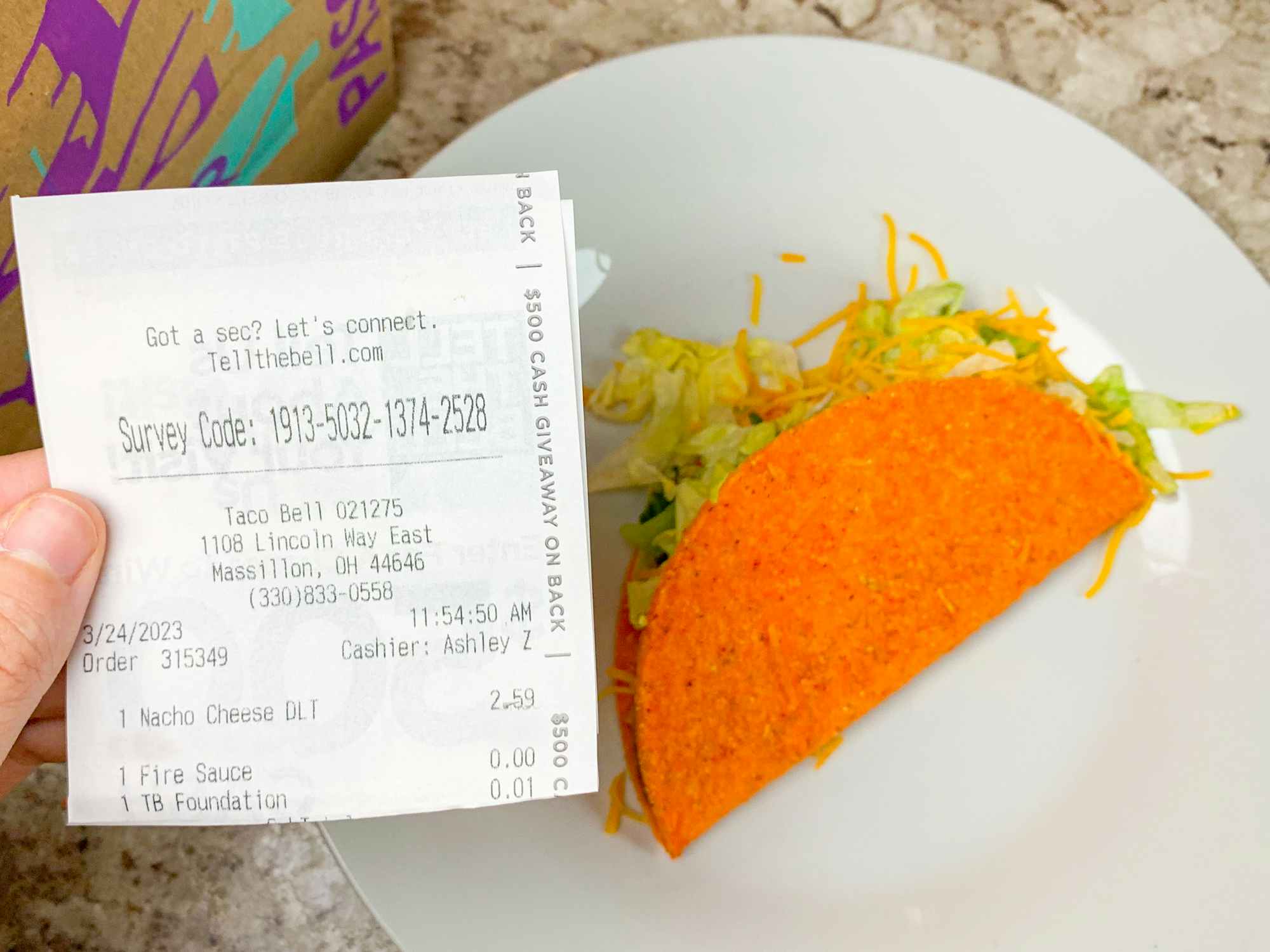 a person holding a store receipt in front of a doritos locos taco