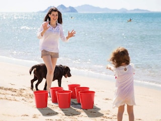 teenager and child playing yard pong on beach