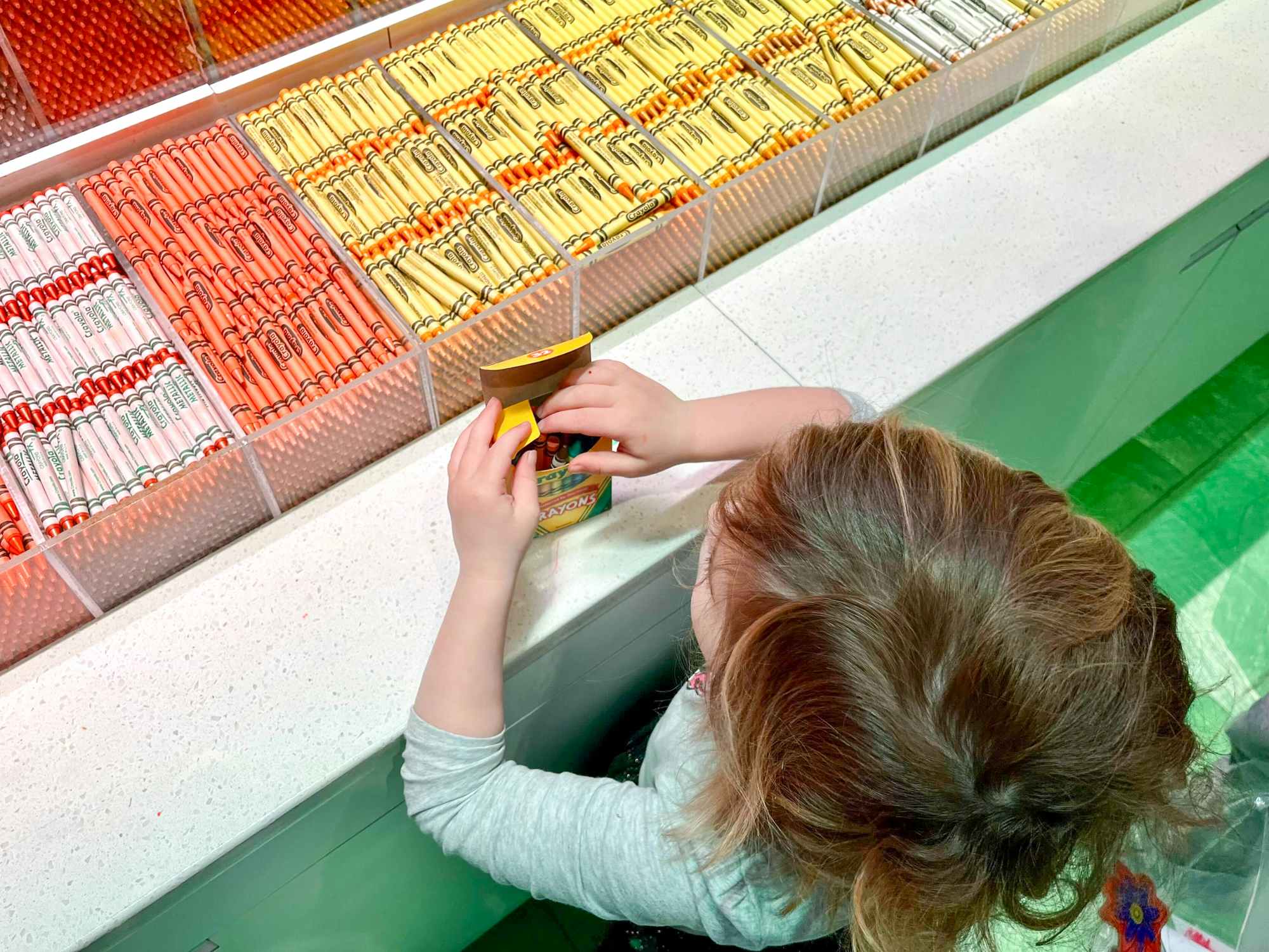 A child picking out crayons at the Crayola Experience location
