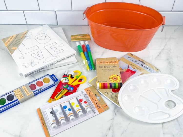 items to make a painted arts and crafts gift basket on counter 