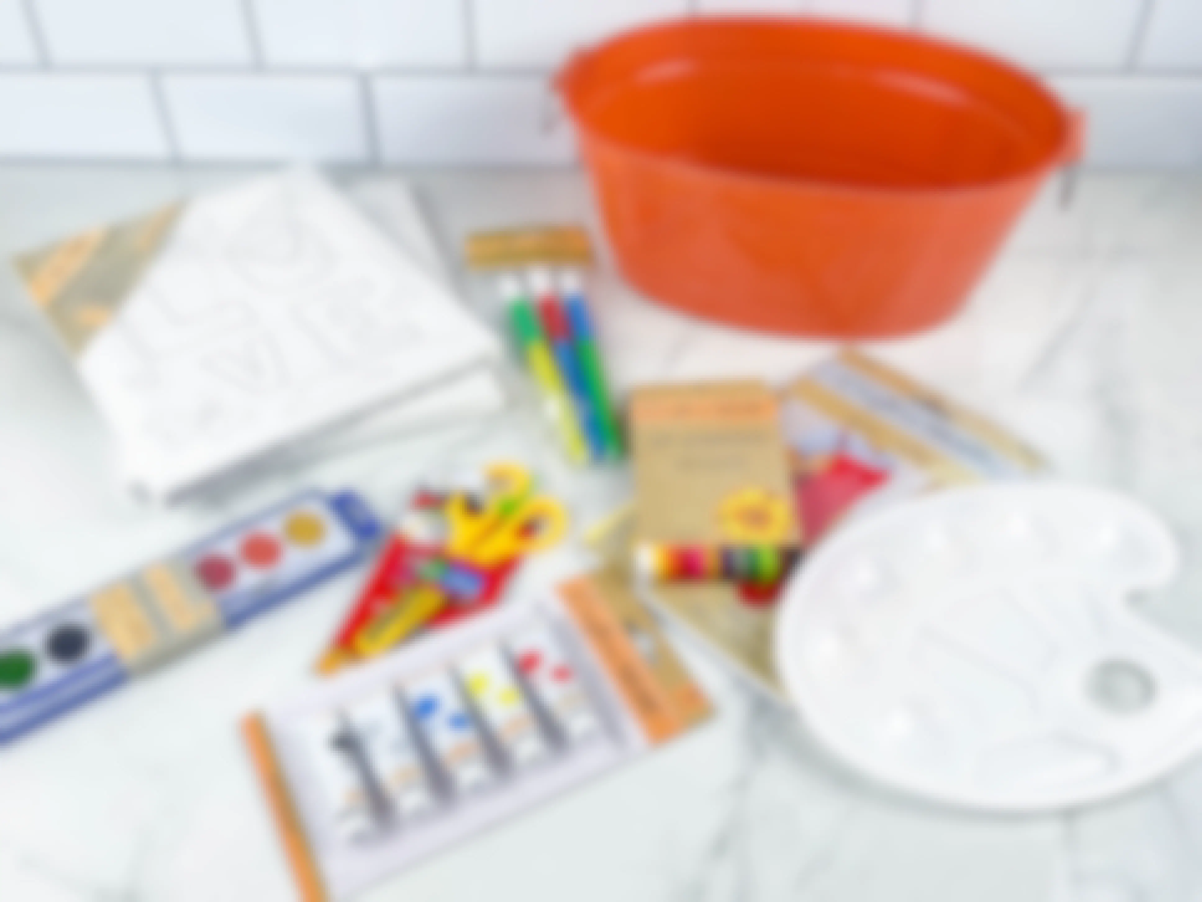 items to make a painted arts and crafts gift basket on counter 