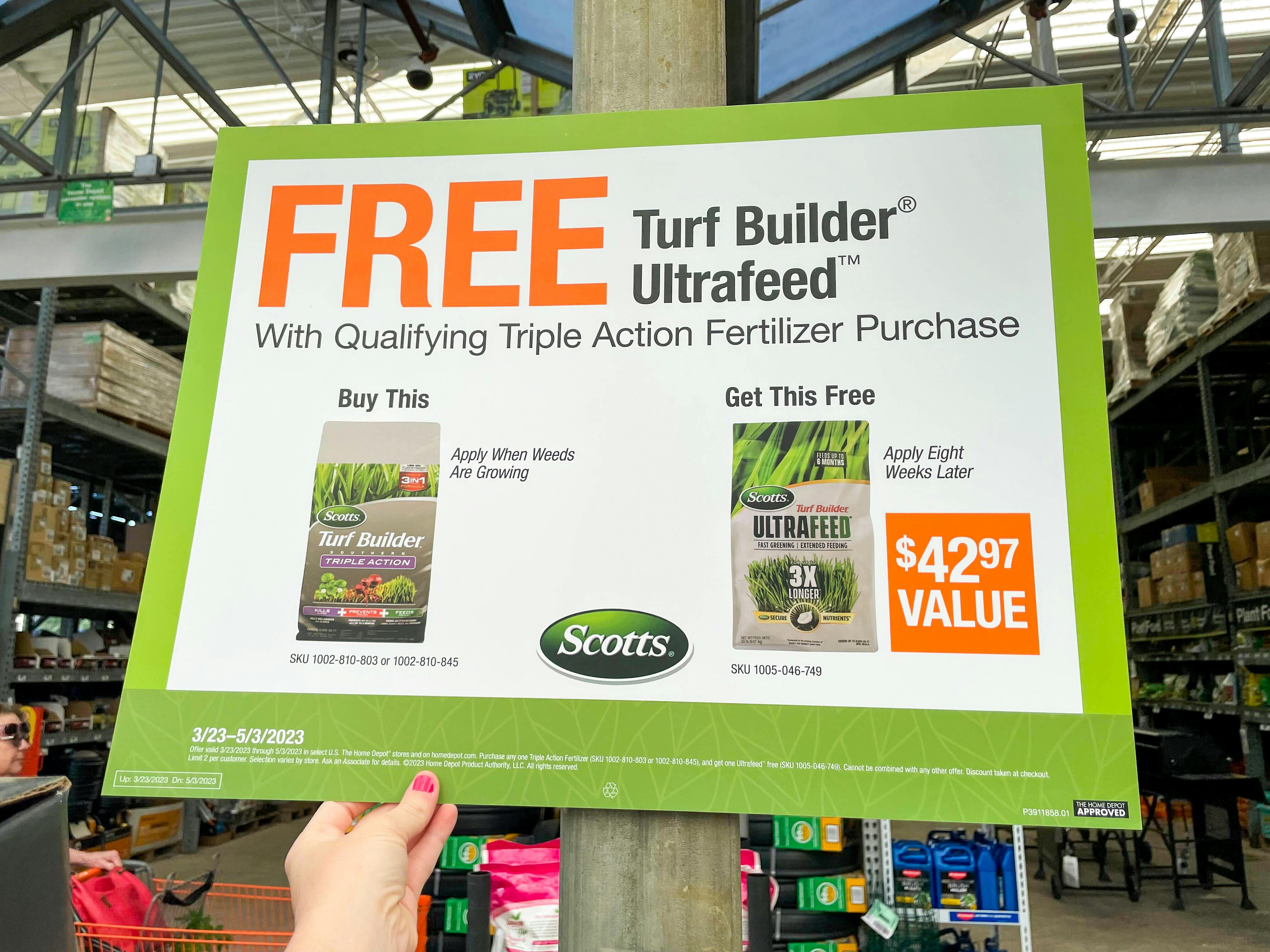 A sign that promotes a FREE turf builder ultrafeed with a qualifying triple action fertilizer purchase at the Home Depot