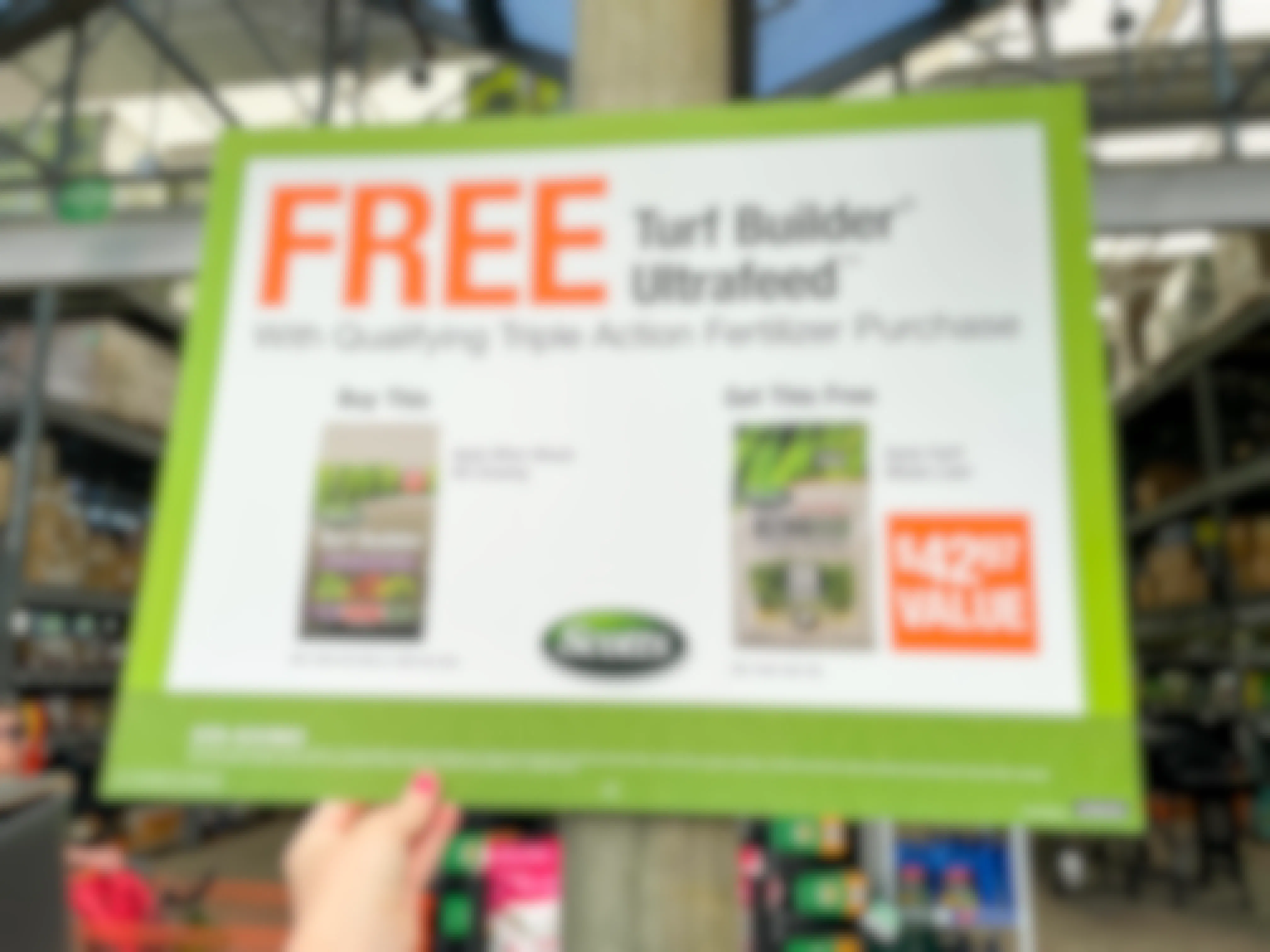A sign that promotes a FREE turf builder ultrafeed with a qualifying triple action fertilizer purchase at the Home Depot