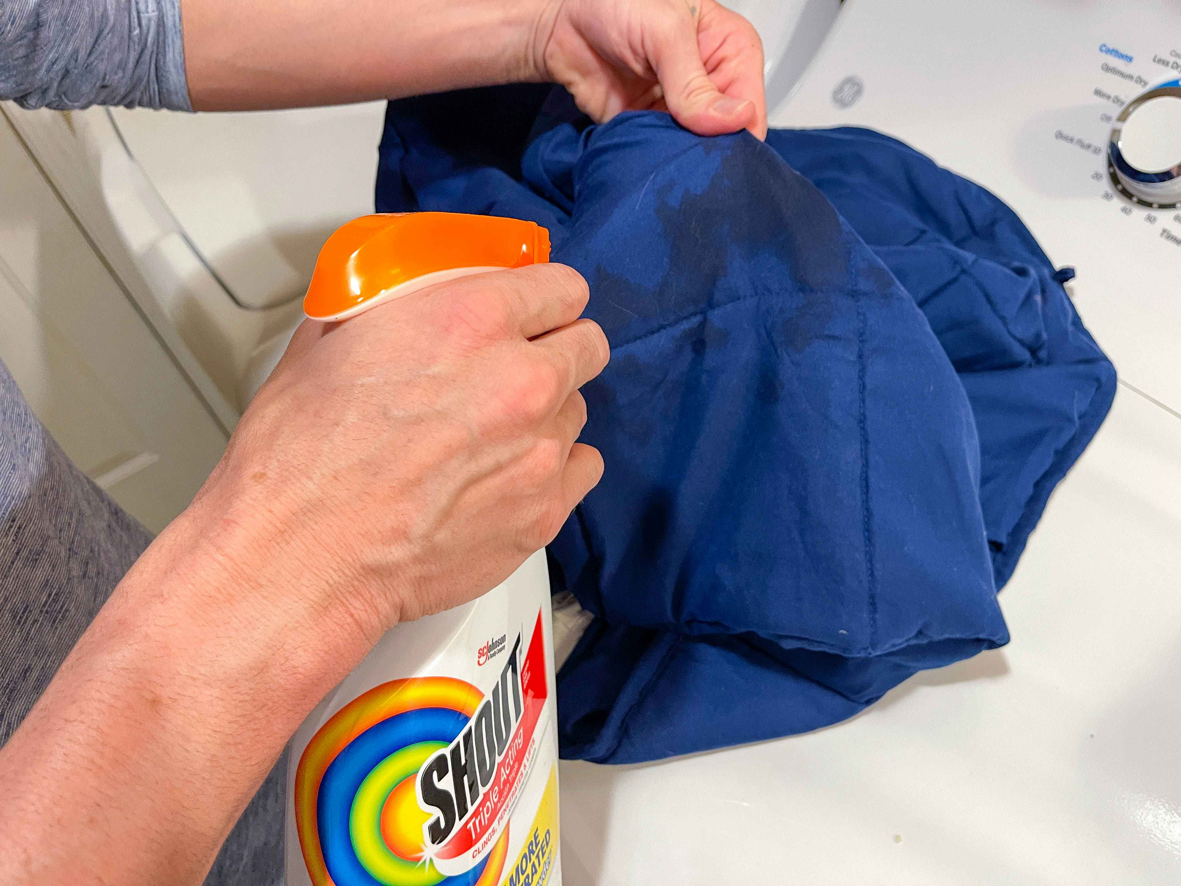 a person spraying stain removed on a weighted blanket