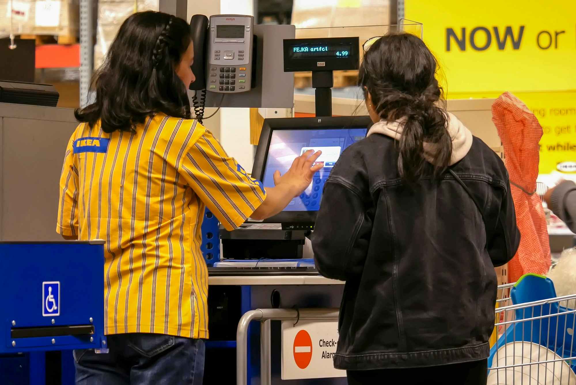 An employee assisting a customer to check out at IKEA