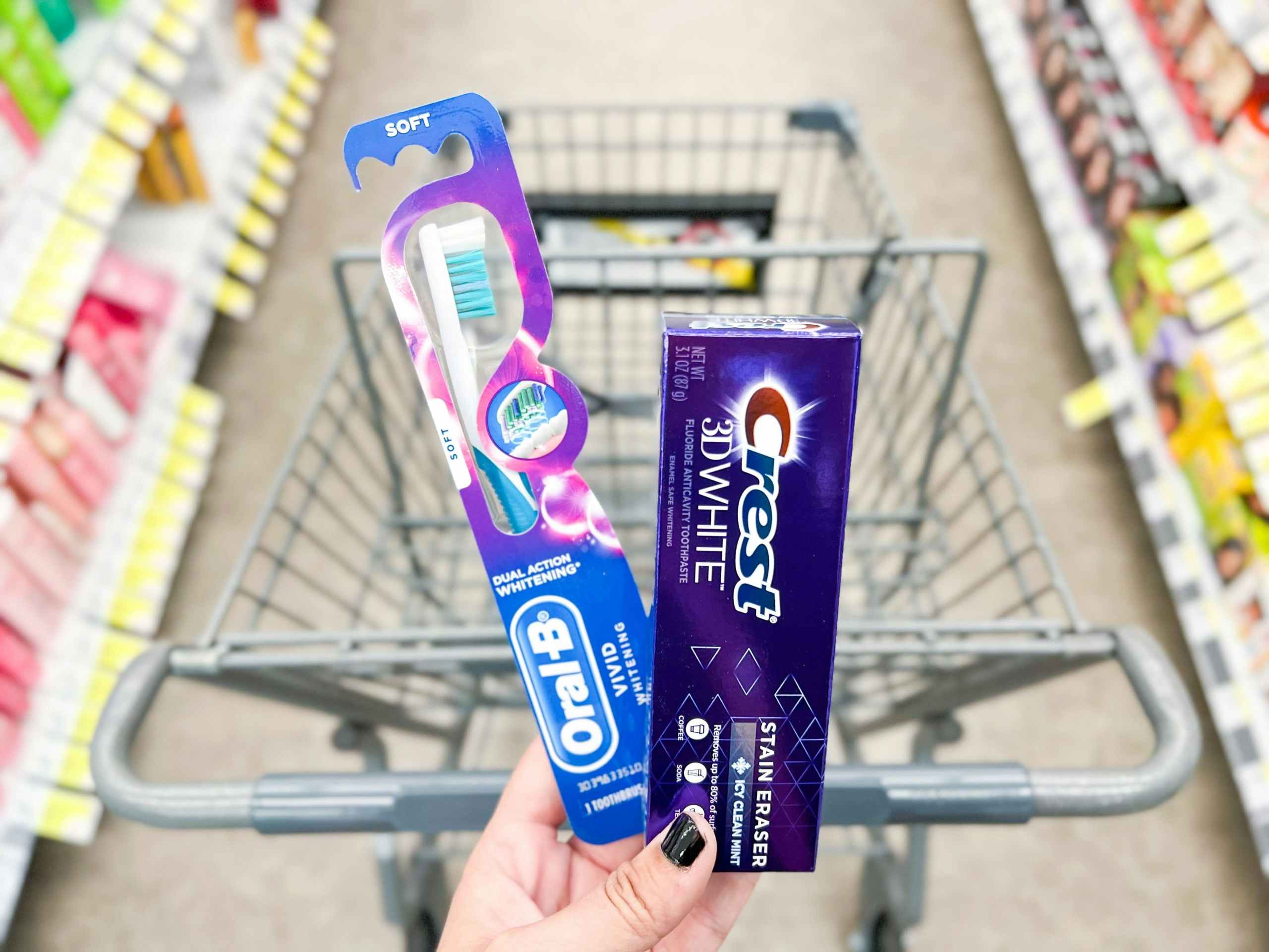 hand holding crest toothpaste and oral-b toothbrush