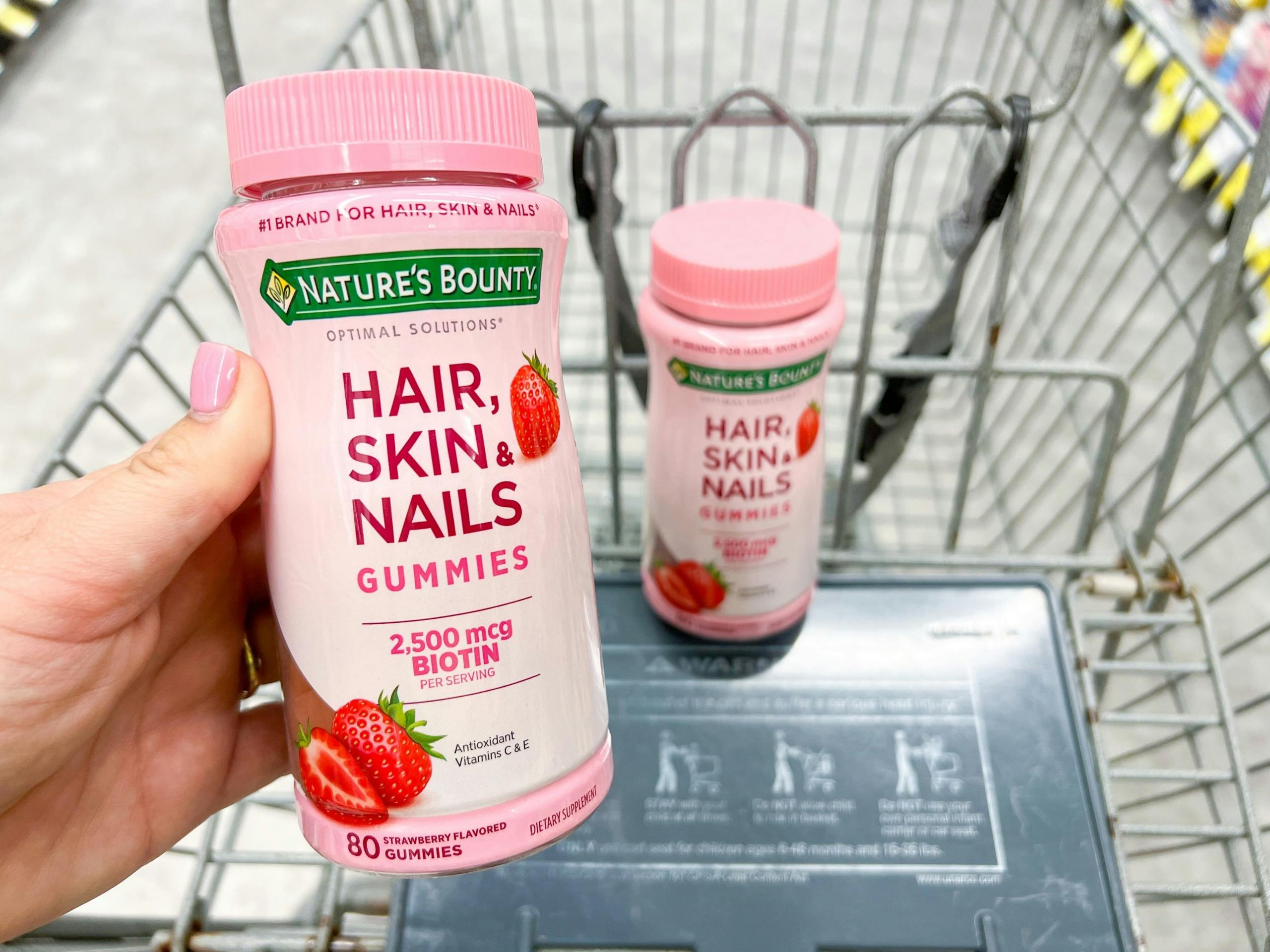 hand holding vitamins in shopping cart