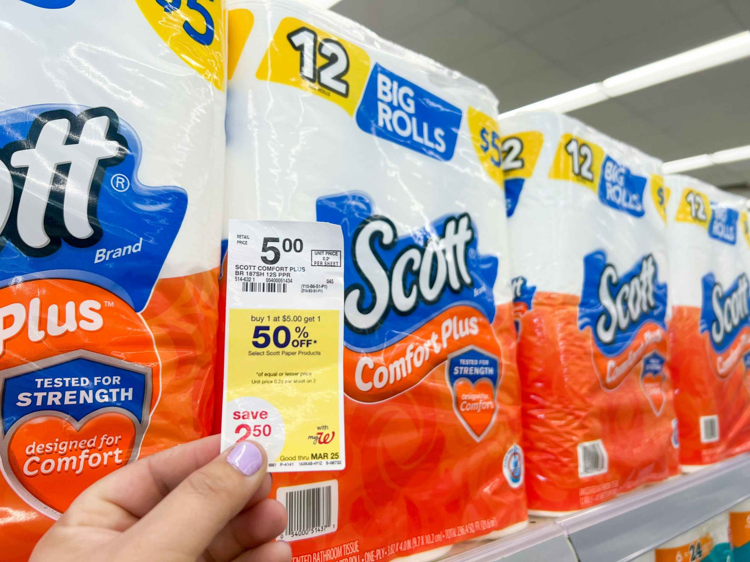 hand holding price tag against scott toilet paper