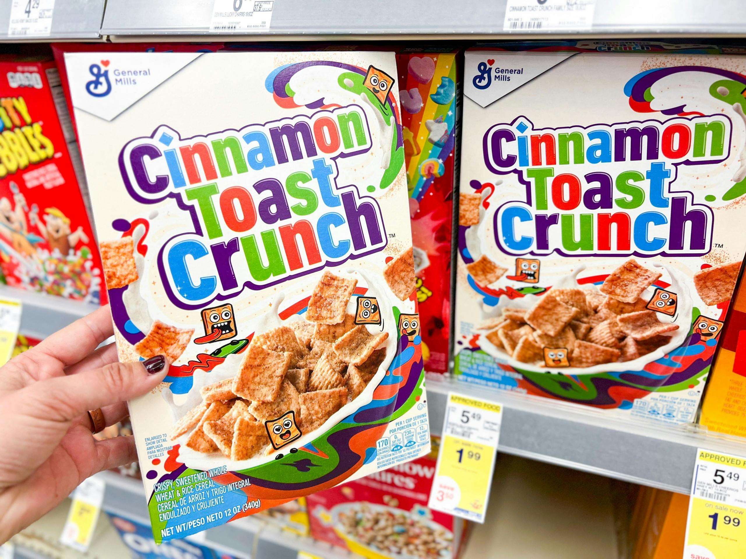 hand holding cinnamon toast crunch next to shelf