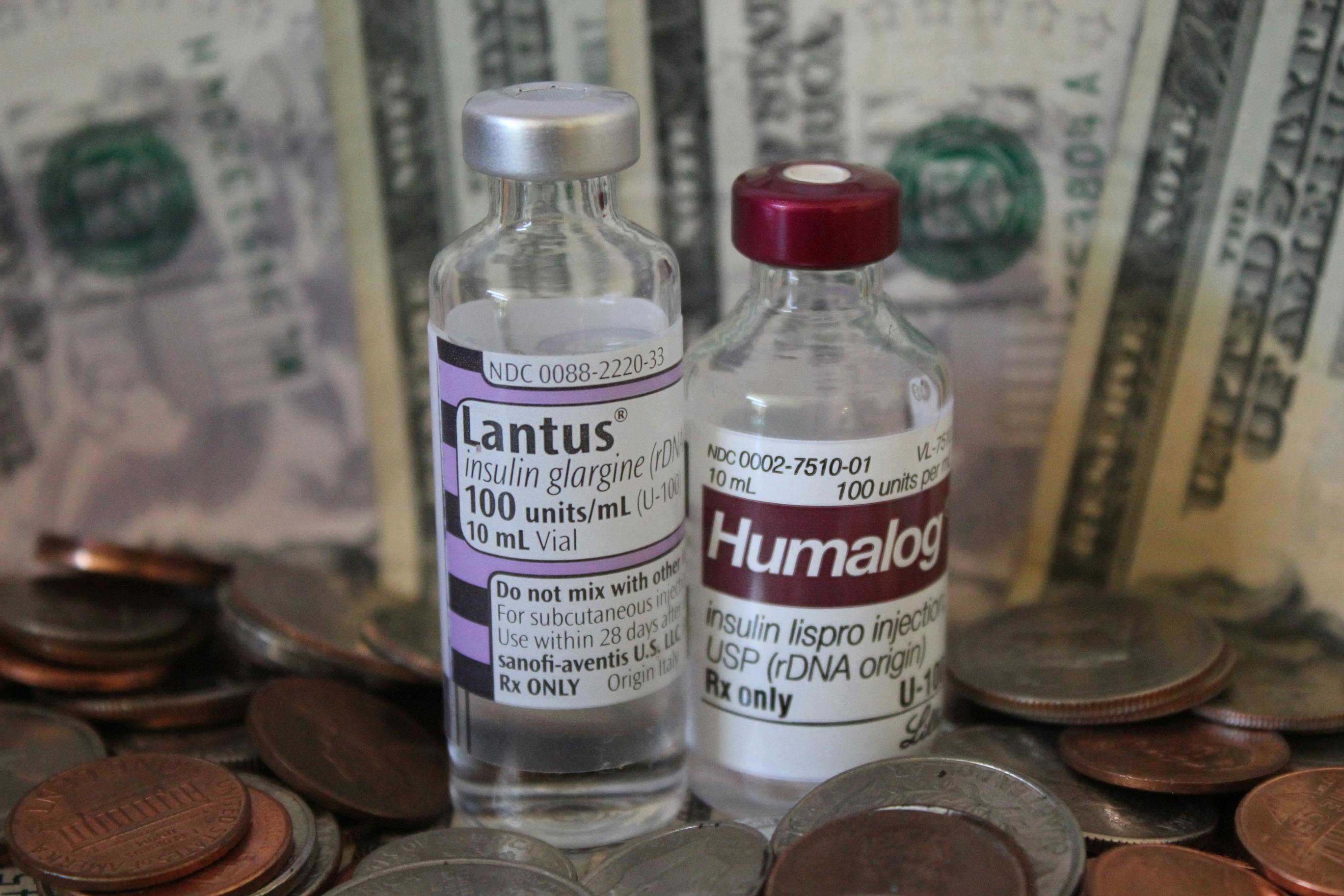 Insulin vials in front of money