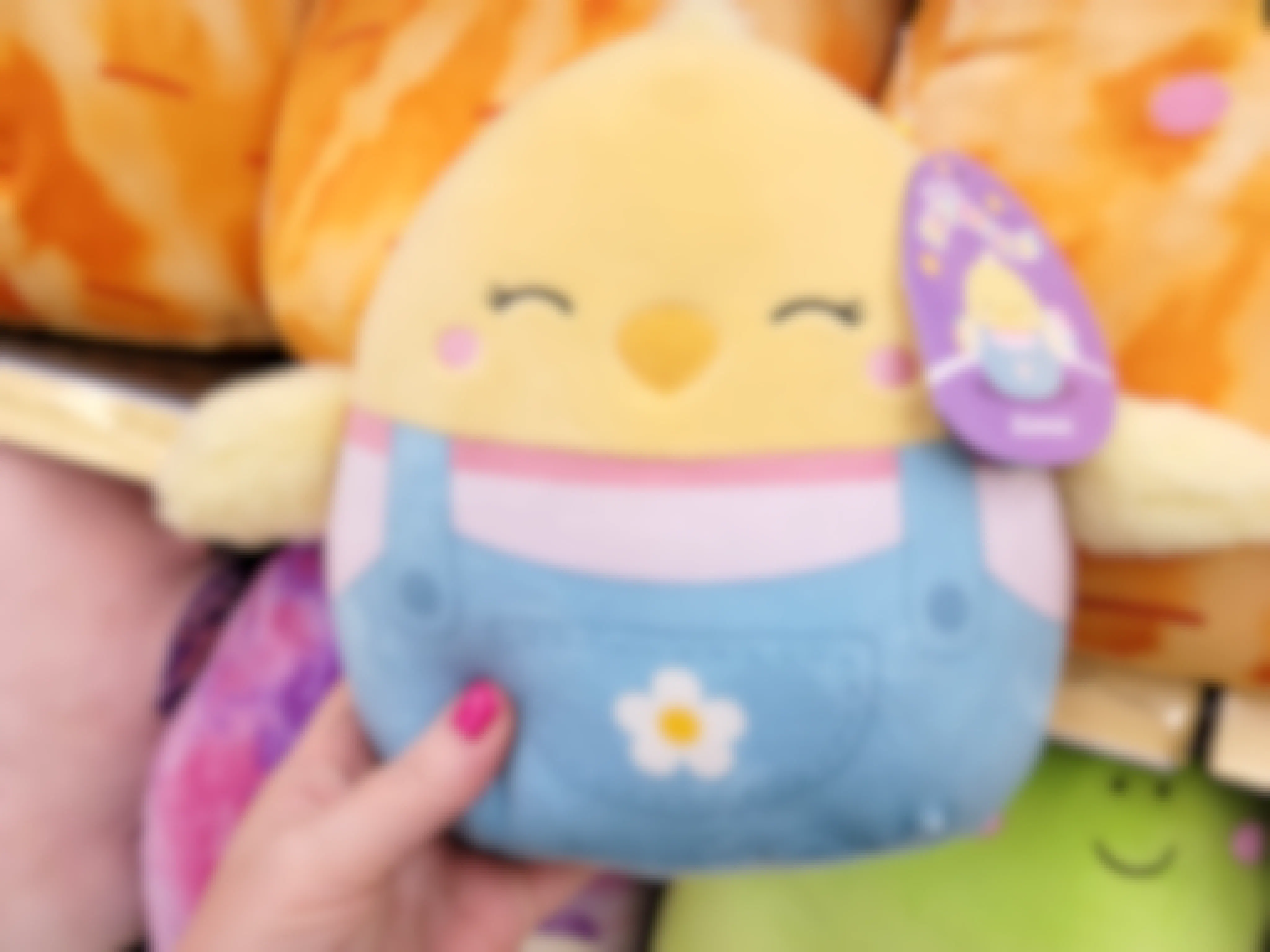 a woman's hand holding an Easter Squishmallow on sale at Kroger