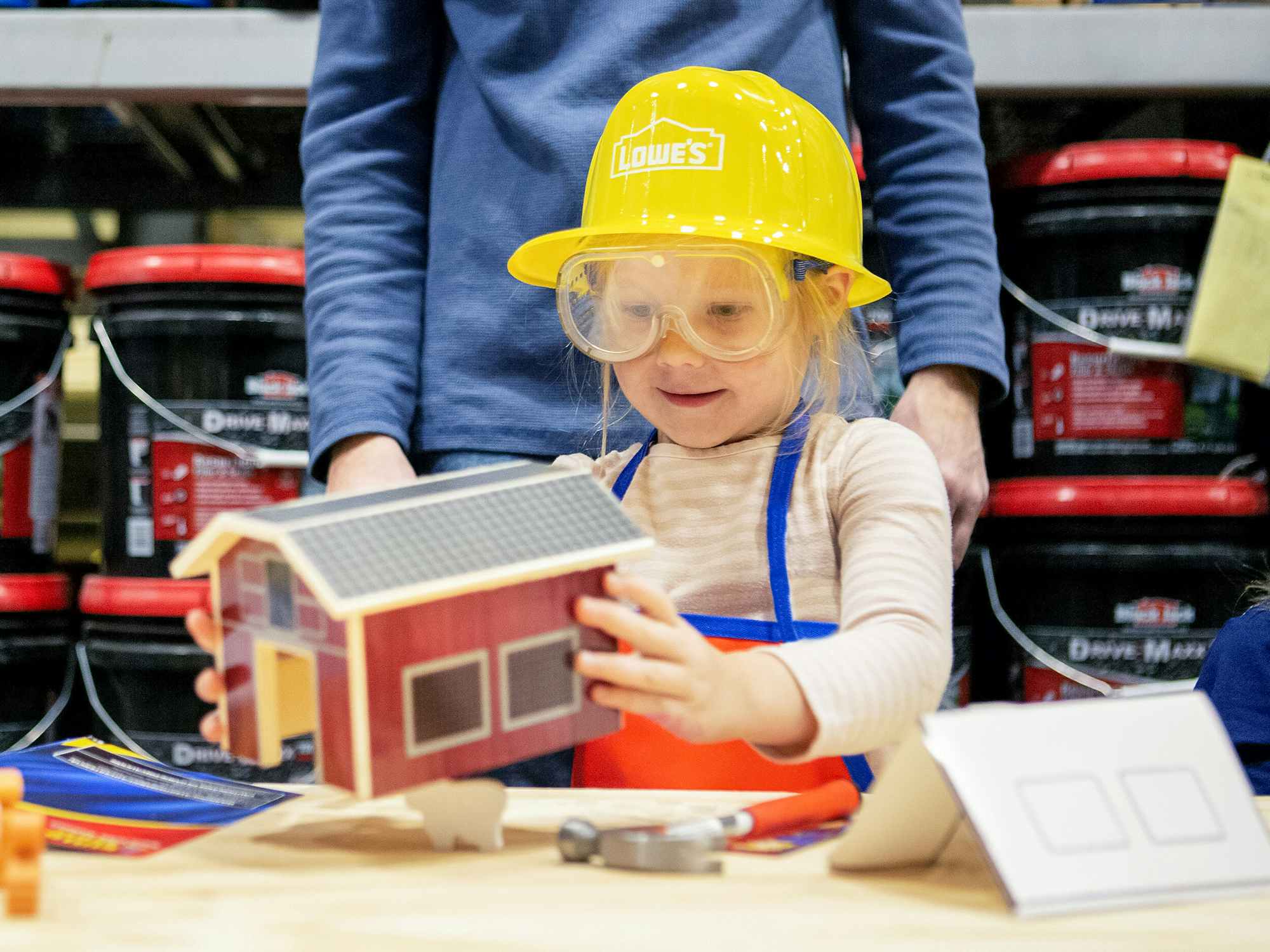 A child sitting at a table working on a DIY project at a Lowe's birthday party