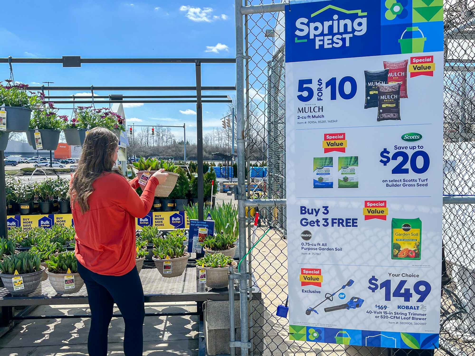 a person looking at a plant outside of a lowes