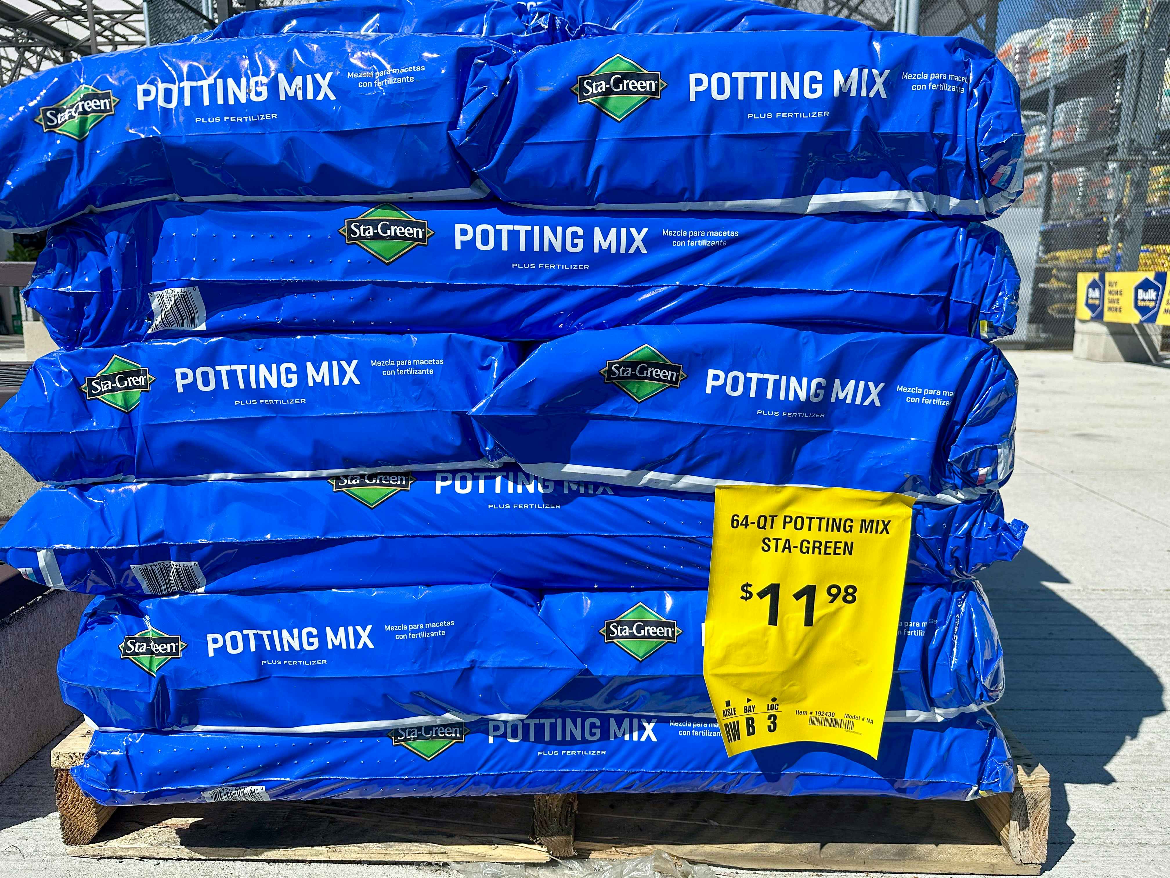 large blue bags of sta-green potting mix stacked on top of one another at the Lowe's garden center