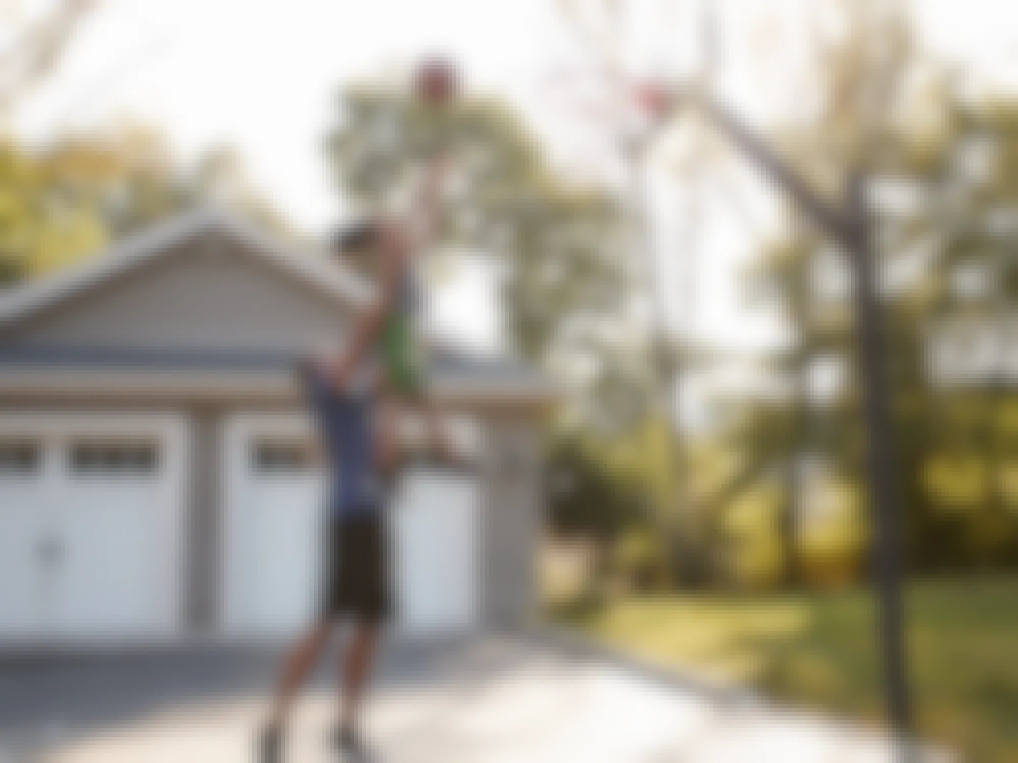 father playing basketball game with child in driveway