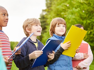 kids standing outside with clipboards