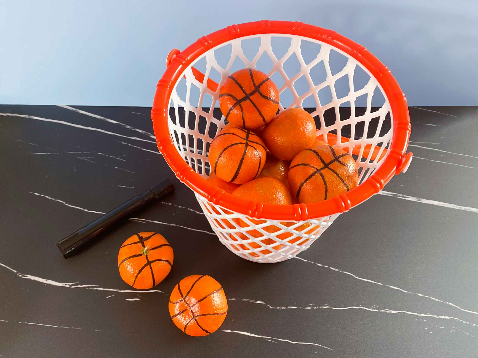 clementines decorated like basketballs with bucket and marker
