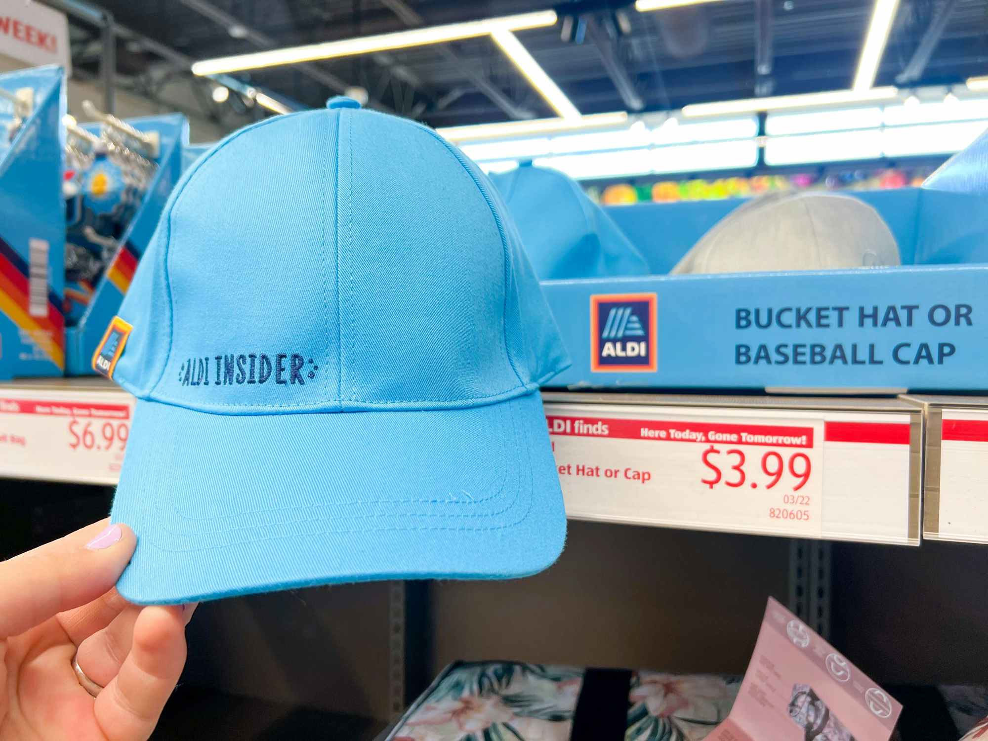a person holding up an aldi baseball hat