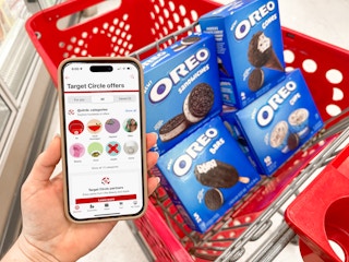 Someone holding their phone displaying the Target app next to a cart full of Oreo frozen treats