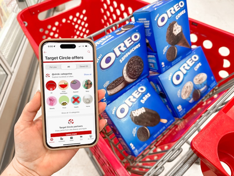 Someone holding their phone displaying the Target app next to a cart full of Oreo frozen treats