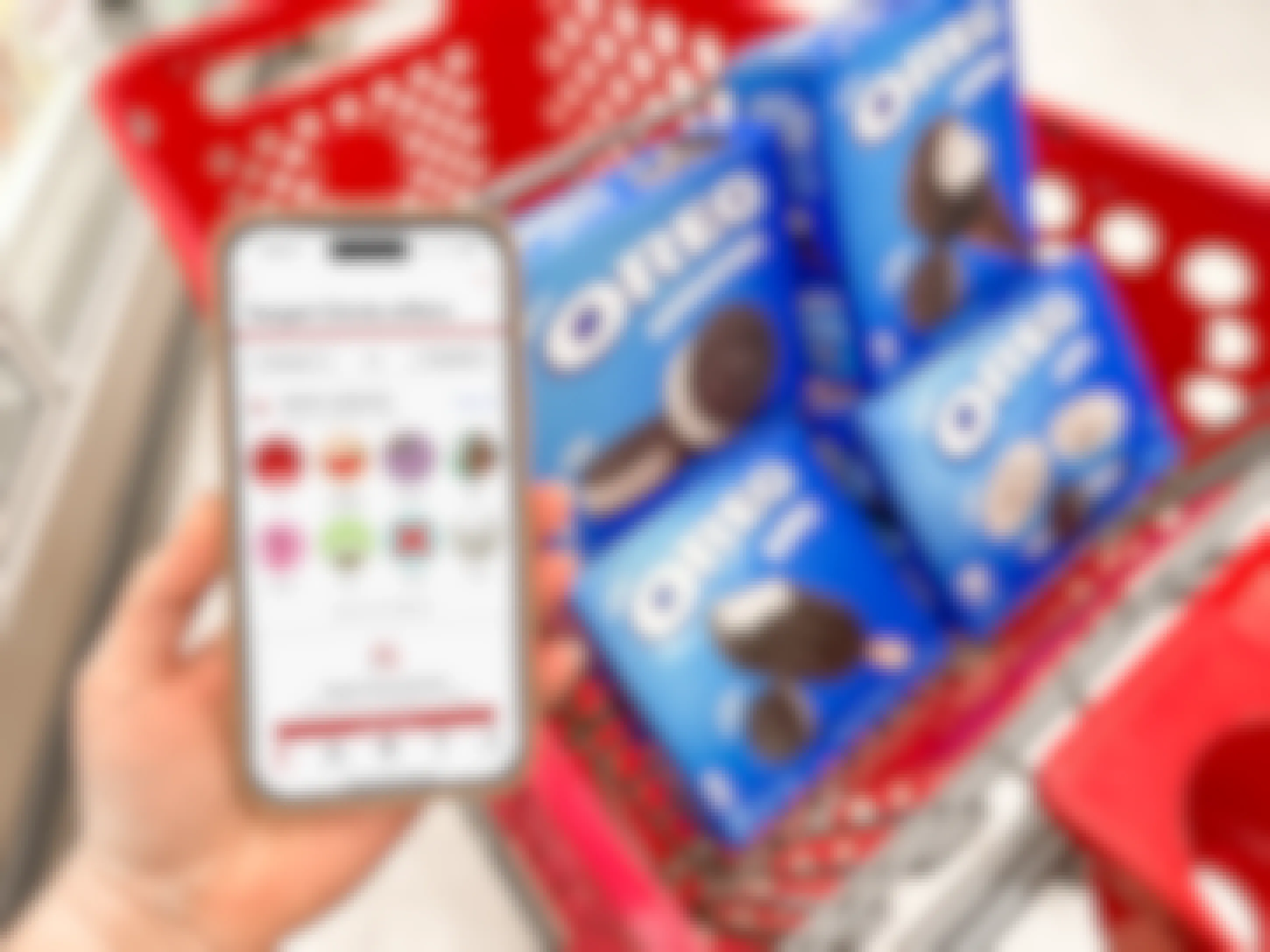 Someone holding their phone displaying the Target app next to a cart full of Oreo frozen treats